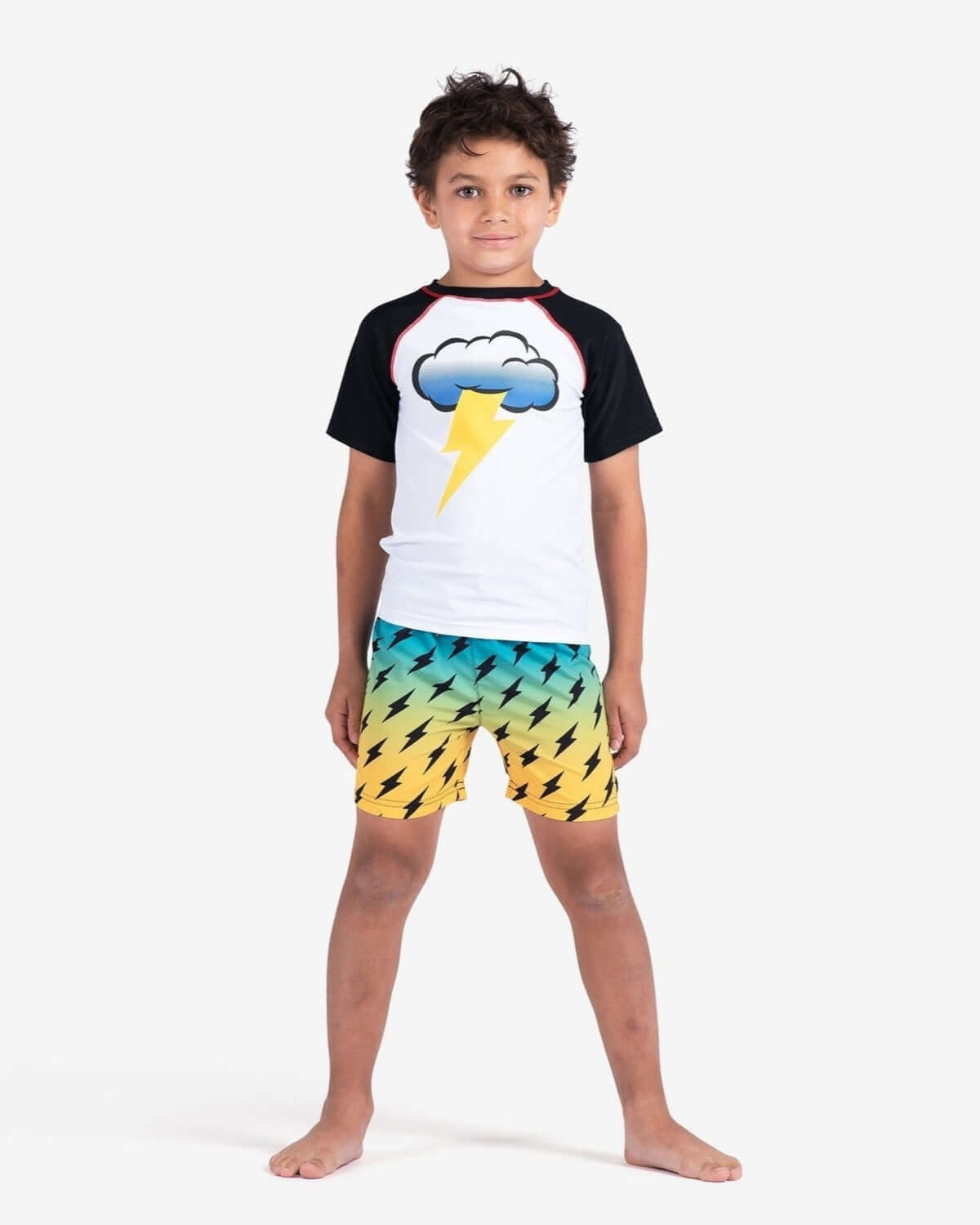 A stylish boy models lightning swim trunks and a matching shirt, ready for fun in the sun this back-to-school season.