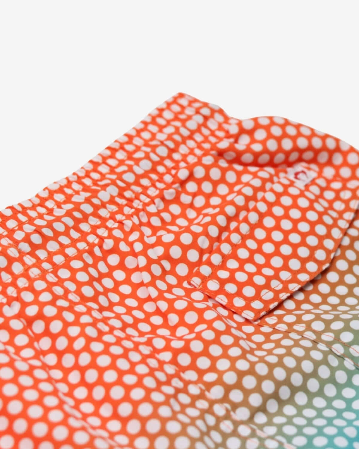 Close-up of Polka Dot Swim Trunks showcasing vibrant blue and orange ombre design with adjustable drawstring.