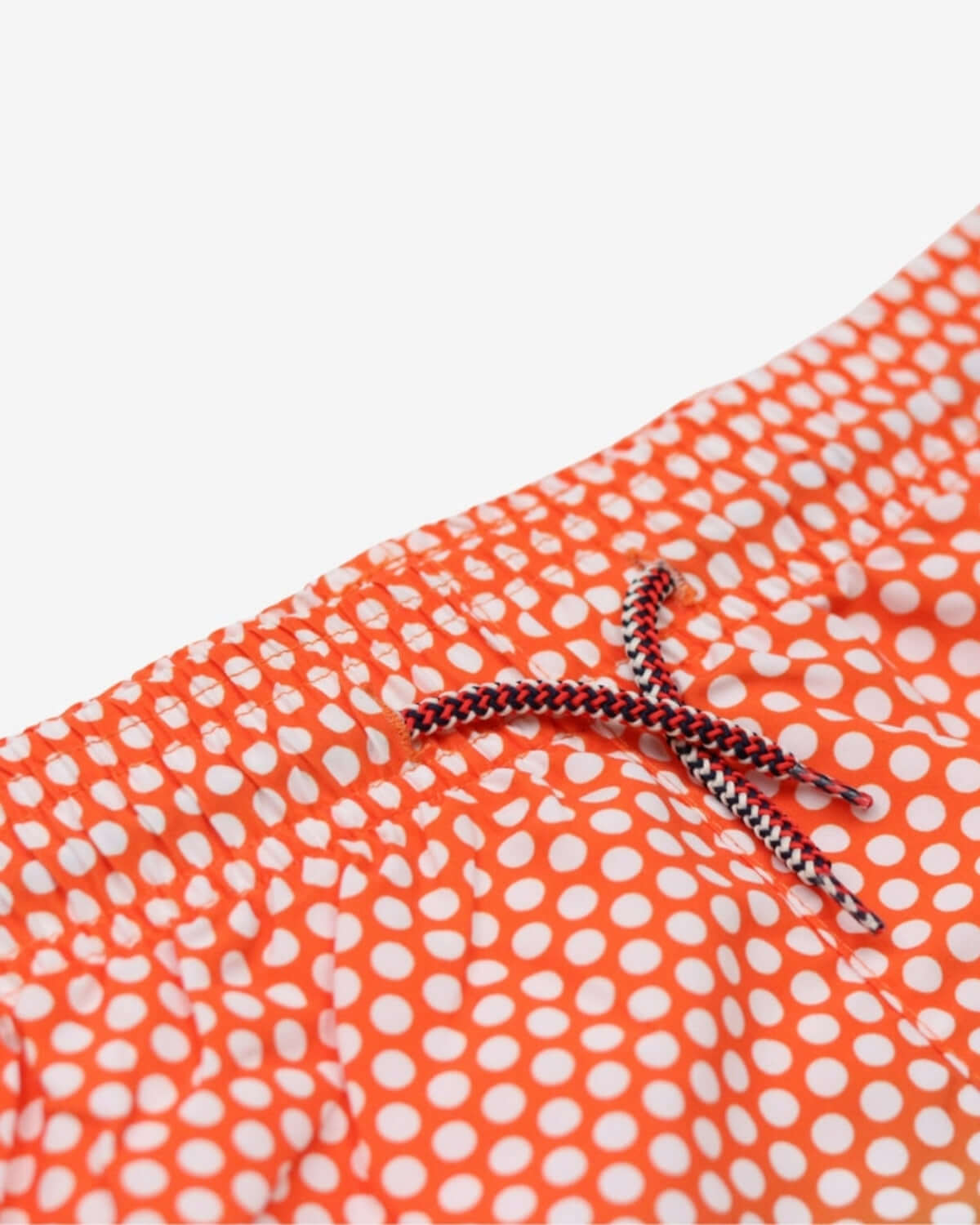 Close-up of adjustable drawstring on Polka Dot Swim Trunks, featuring vibrant orange and white polka dot pattern.