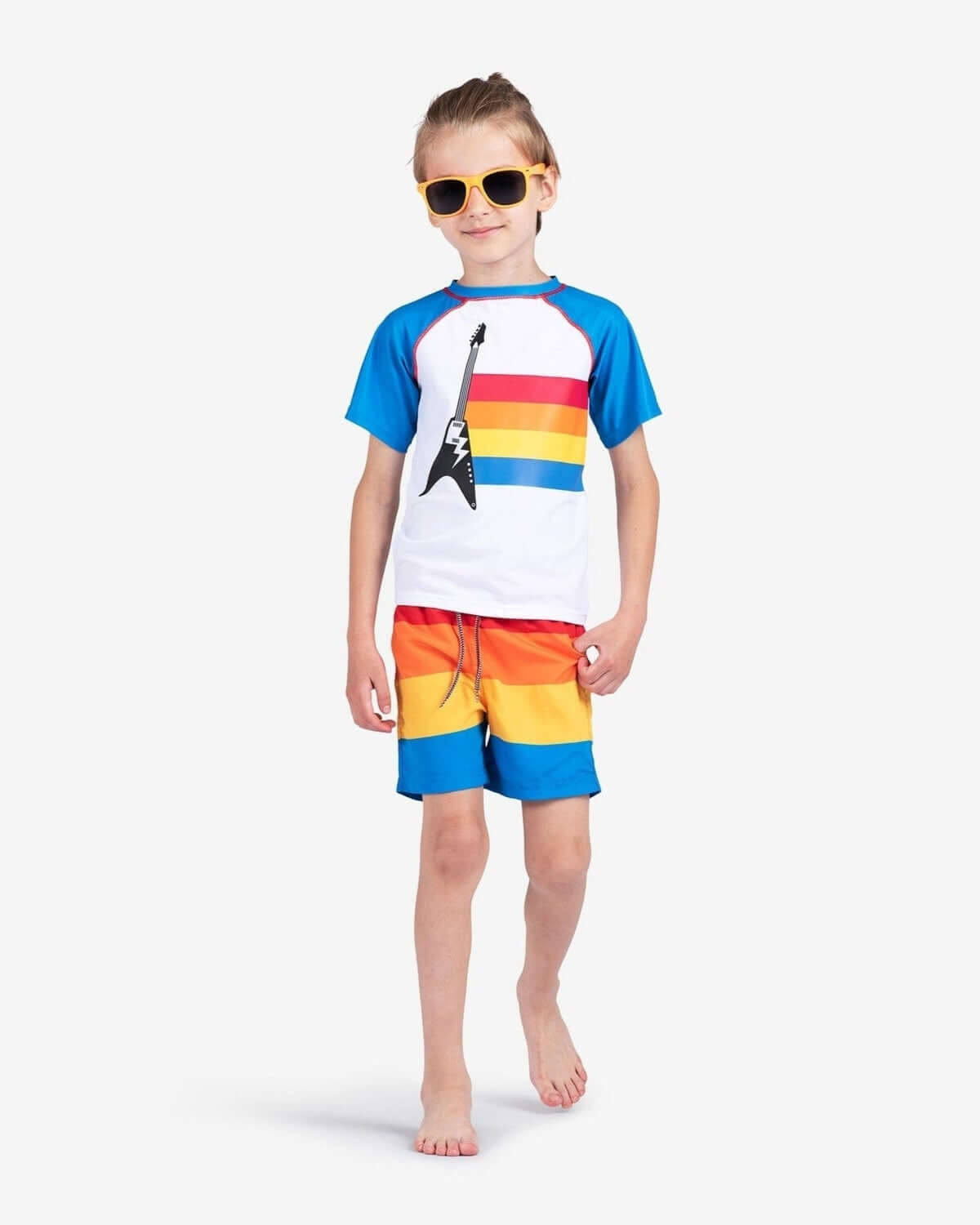 Stylish kid rocking retro stripes swim trunks and a fun tee, ready for summer adventures in high-quality kids clothes!