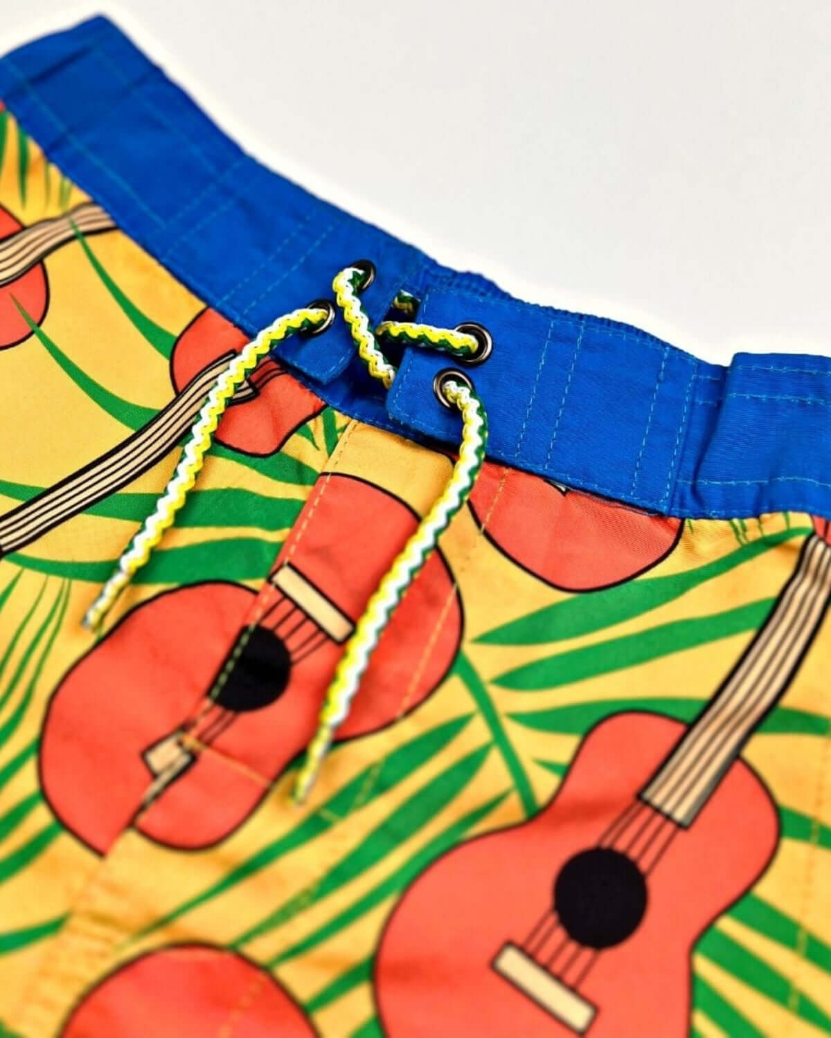 Close-up of Ukulele Paradise Swim Trunks highlighting the colorful ukulele design and adjustable waistband.
