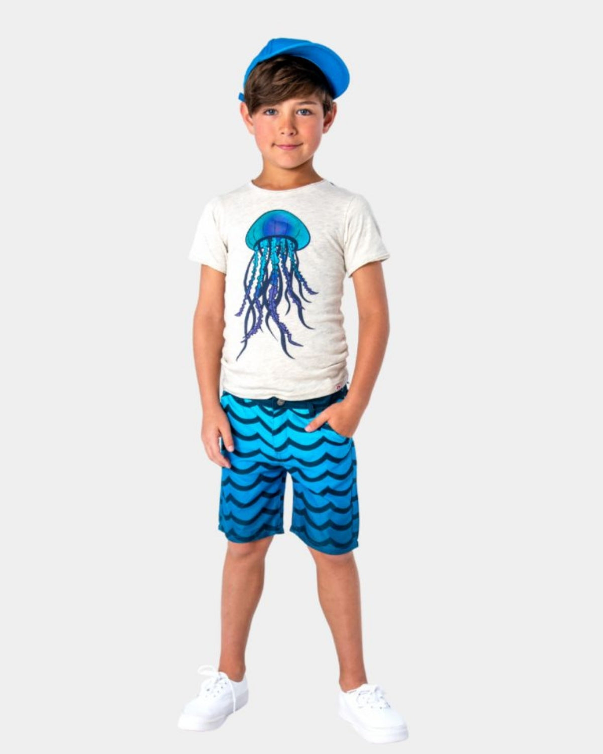 Stylish boy rocking wavy blue hybrid swim shorts and a jellyfish tee—perfect for summer adventures!