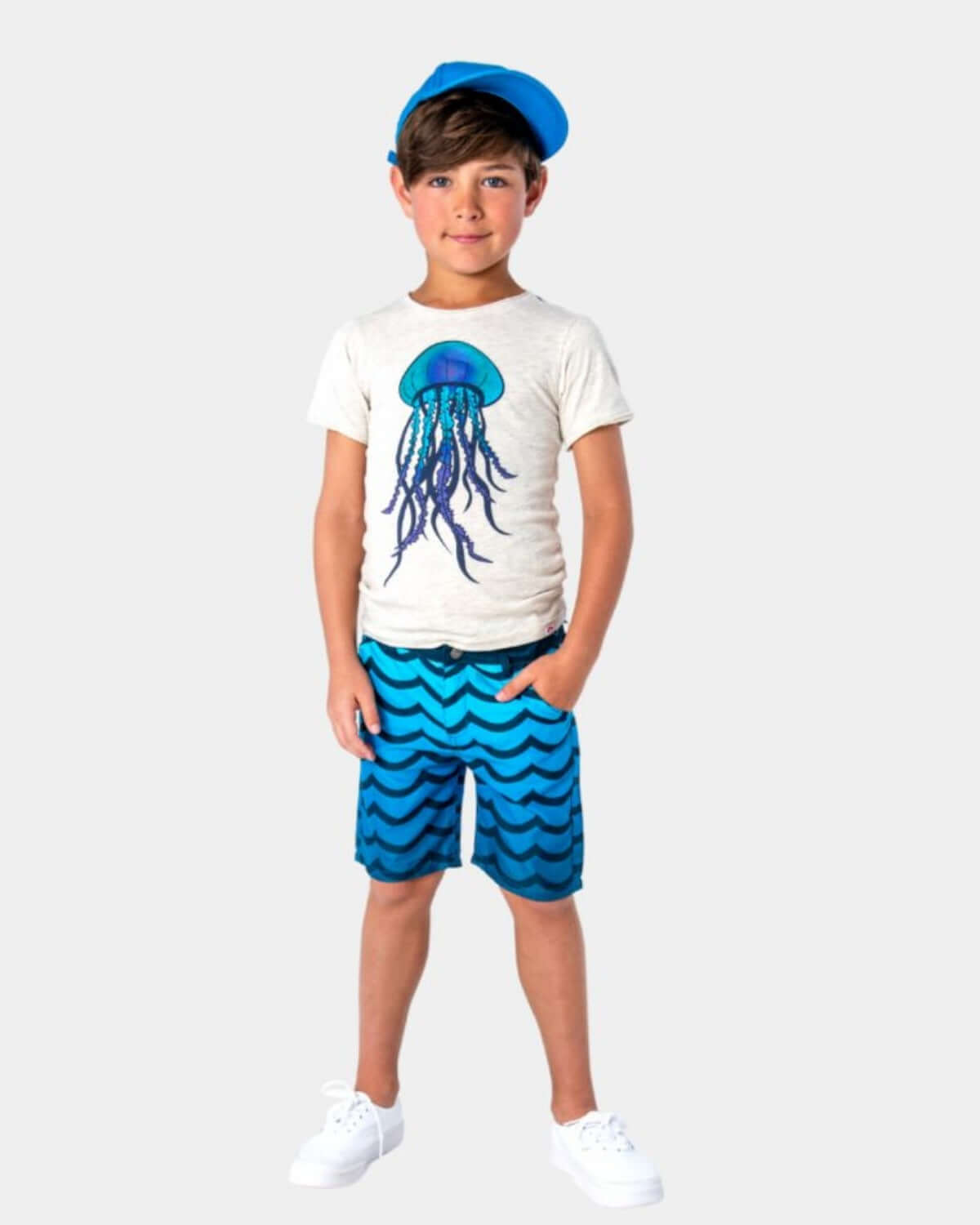 Boy wearing Wavy Blue Hybrid Swim Shorts with a jellyfish t-shirt and blue cap.