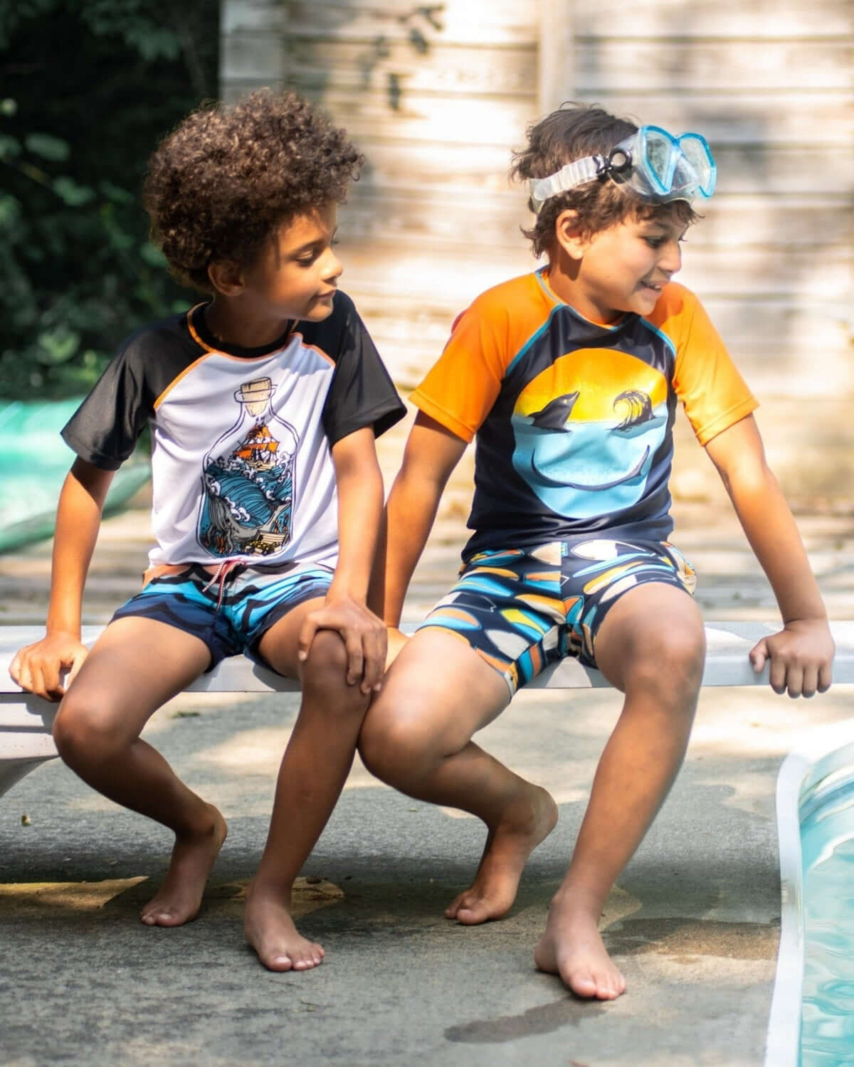 Two boys in colorful swim trunks, ready for splashy fun by the pool—stylish and safe with UPF protection!