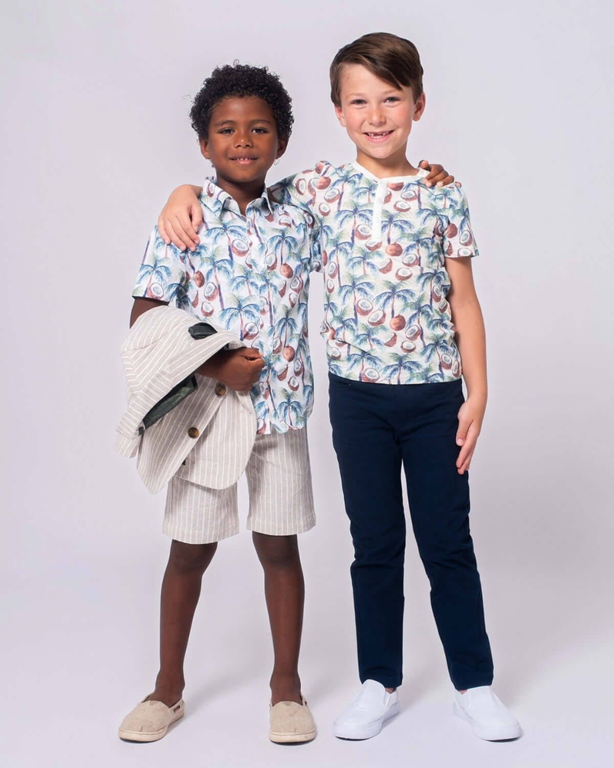 Two stylish boys in playful coconut palm clothes, showing off fun kids fashion—perfect for back-to-school vibes and sunny playdates!