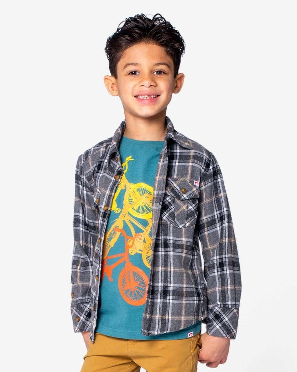 Cheerful boy flaunting a Greige Plaid Flannel Shirt over a fun graphic tee—perfect for stylish fall adventures!