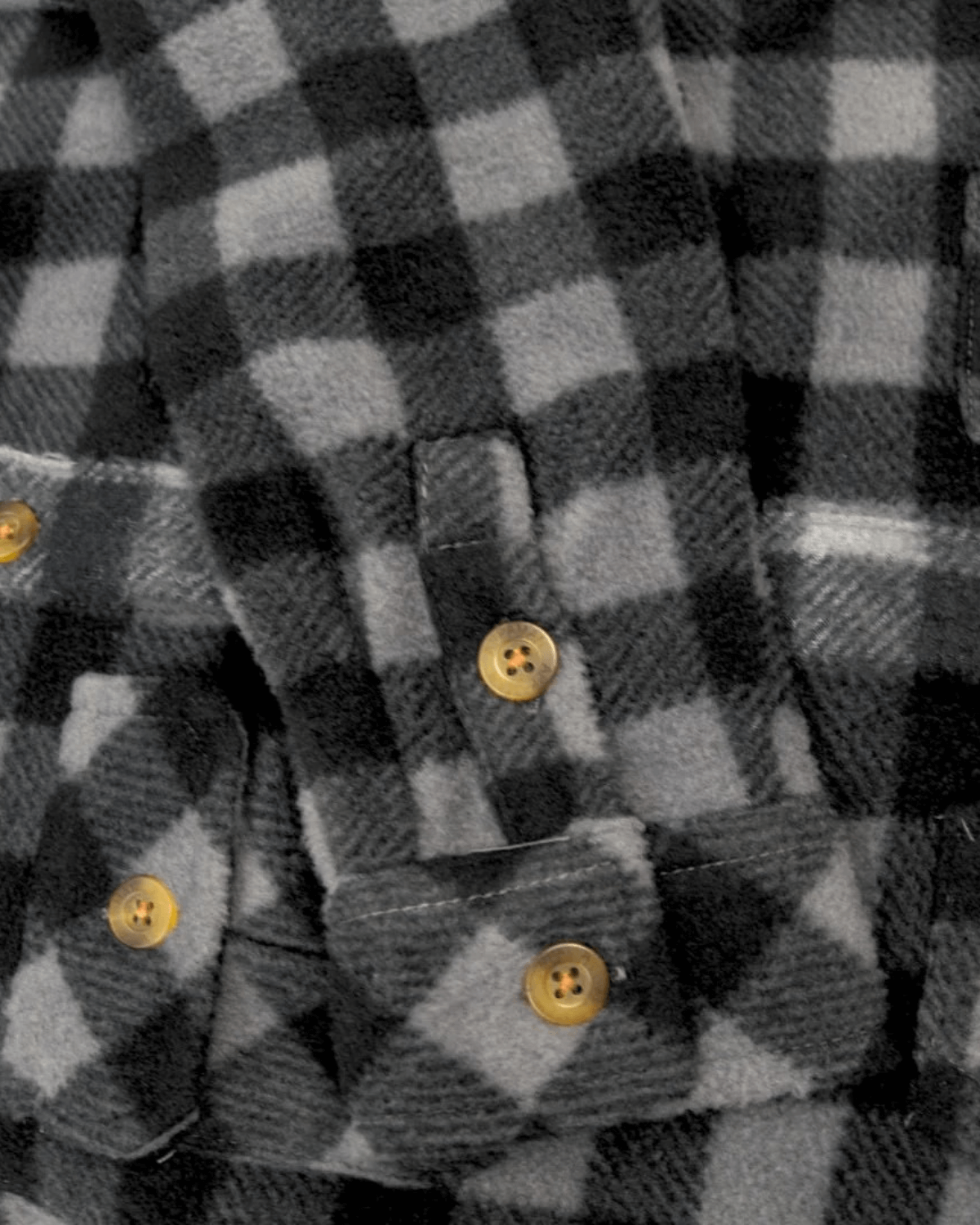 Close-up of the cozy grey and black check snow fleece shirt for kids, featuring stylish buttons and snuggly fabric.