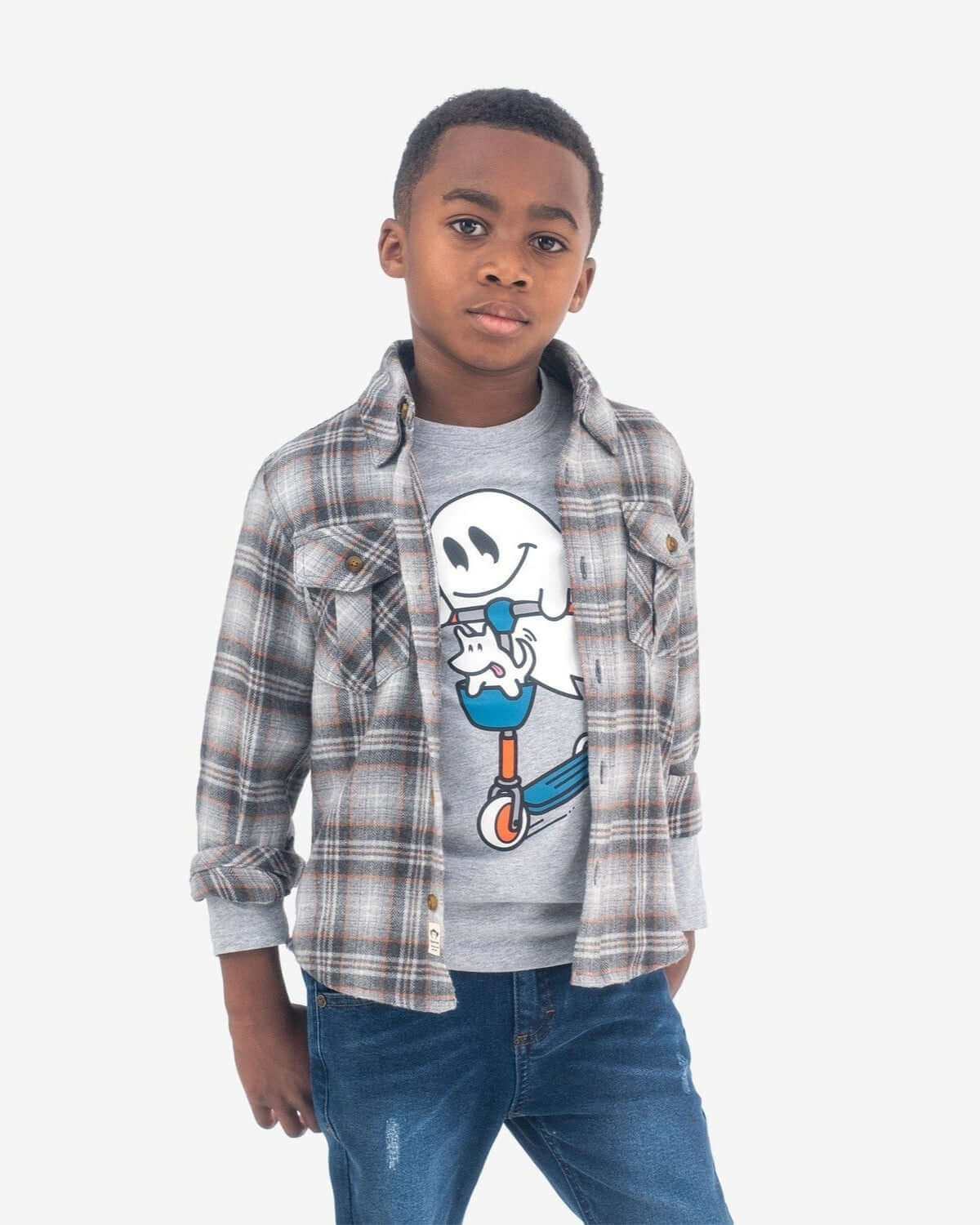 Boy wearing a Grey/Orange Plaid Flannel Shirt over a graphic tee, showcasing stylish fall fashion.