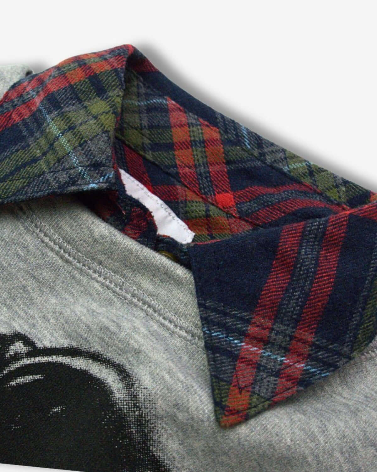 Close-up of a navy and cranberry plaid collar on a stylish grey flannel shirt for kids, bringing cozy vibes to their wardrobe.