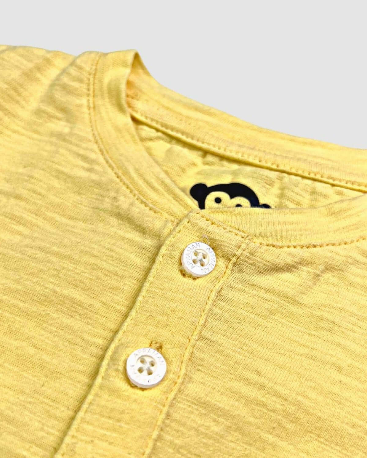 Pale Yellow Day Party Henley close-up showing buttons and fabric texture.