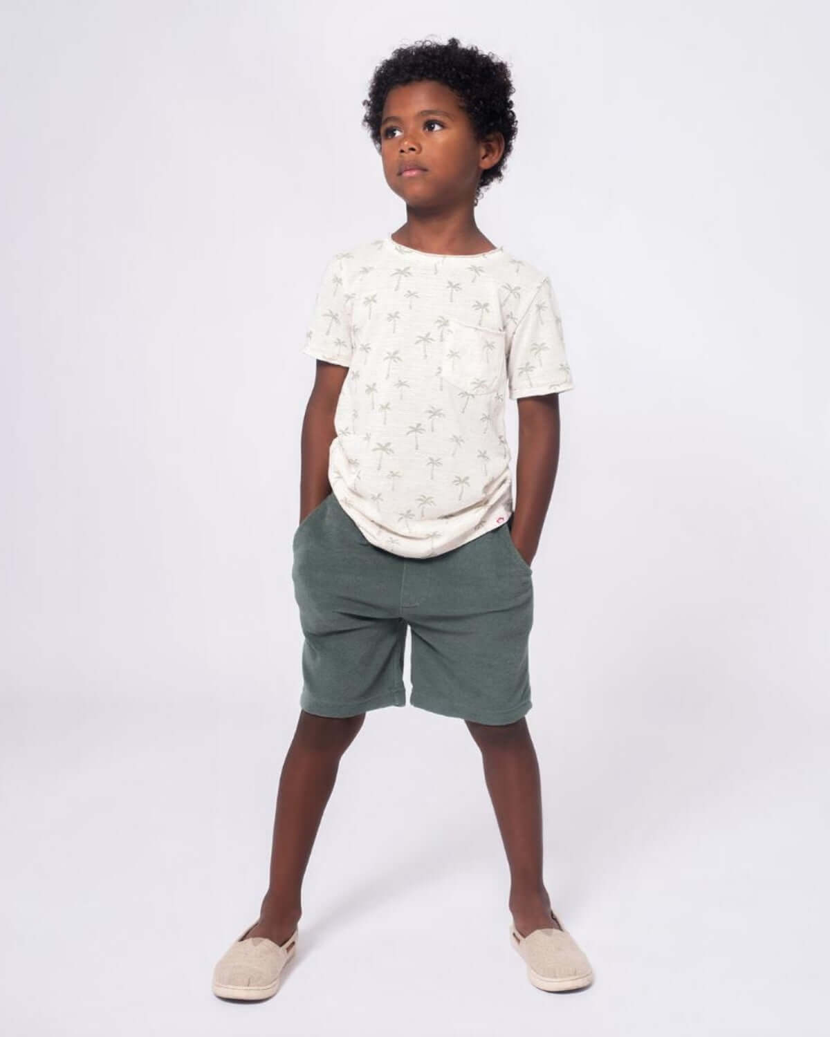 Stylish boy in a palm-print tee and comfy shorts, ready for summer adventures in high-quality kids clothes!