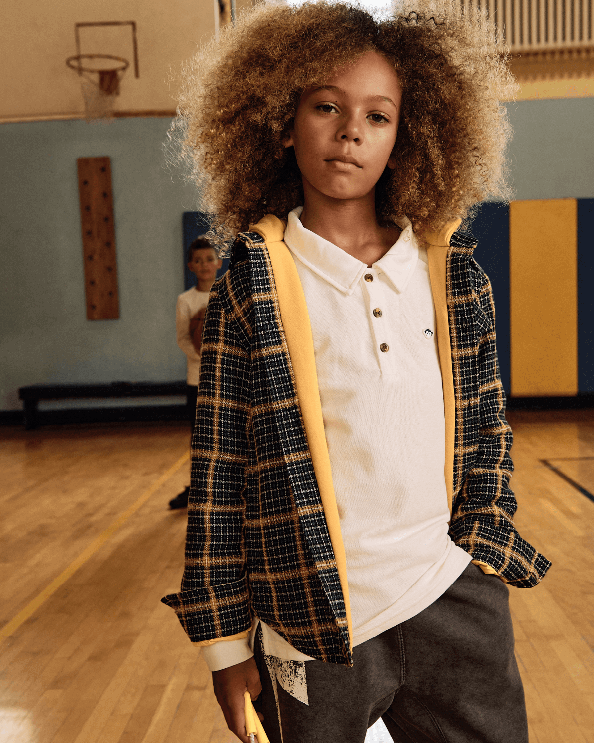 Stylish kid in a checkered jacket over a white Parker Polo, ready for fun in high-quality boys and girls clothes.