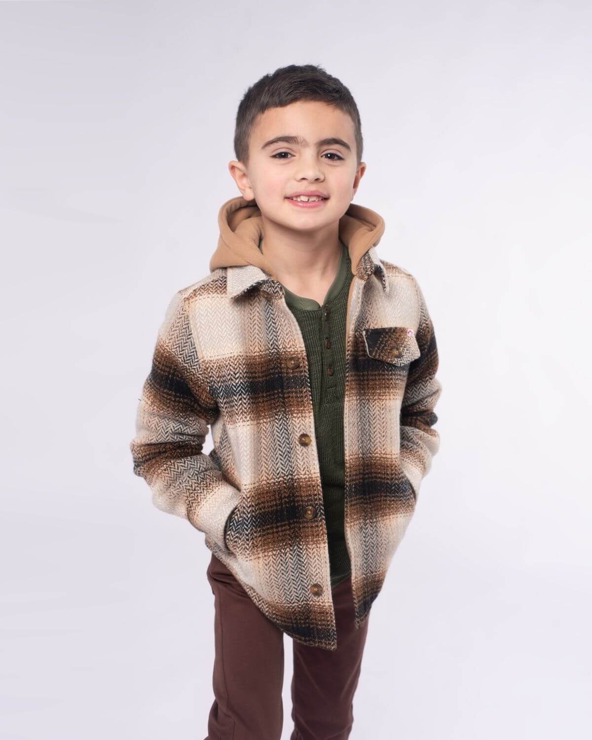 Stylish boy in a plaid jacket with a hoodie, showcasing fun kids clothes ready for back-to-school adventures.