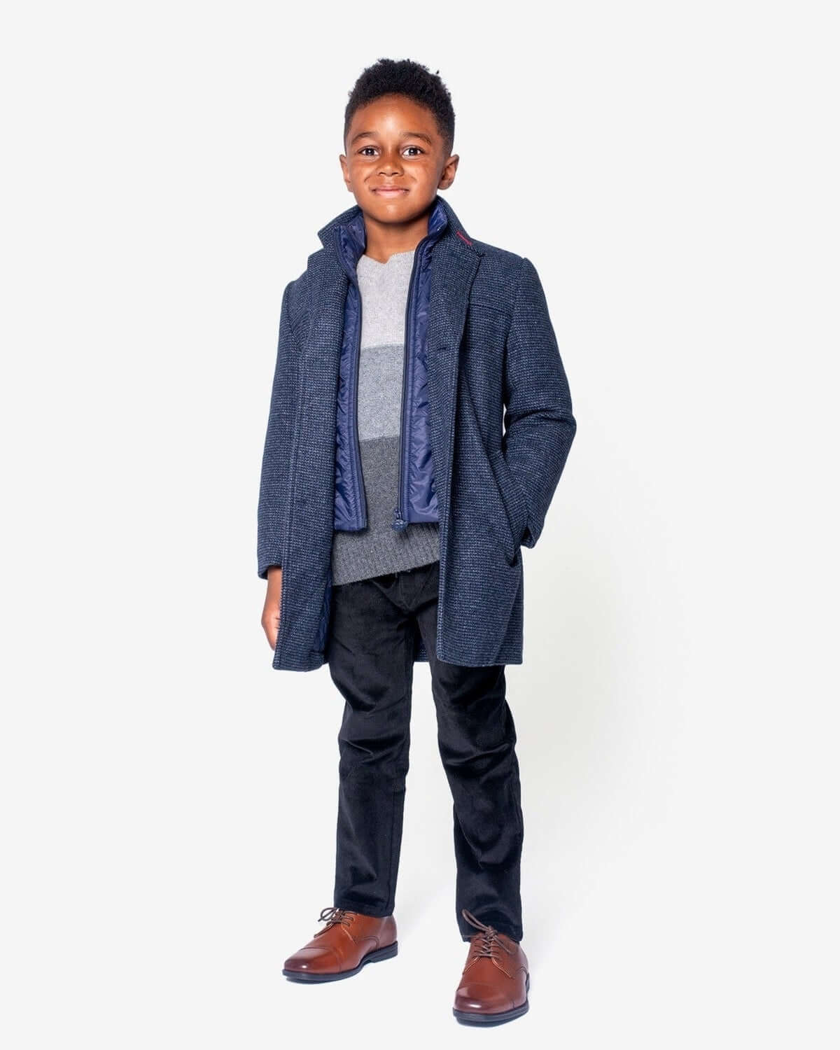 Stylish boy in a sleek navy coat and smart pants—ready for a back-to-school adventure in high-quality kids clothes!