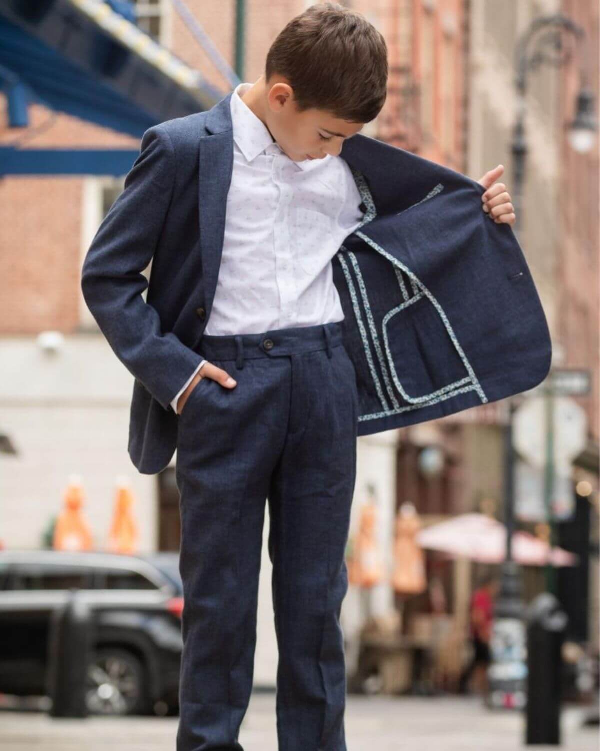 Stylish boy showcasing a tailored navy suit with a chic inner lining, perfect for confident kids on special occasions.