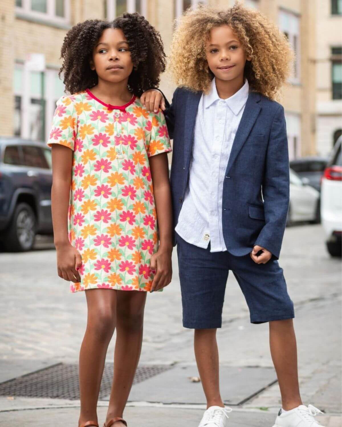 Stylish kids rocking a vibrant floral dress and smart blazer shorts, showcasing fun kids clothes for back to school adventures!