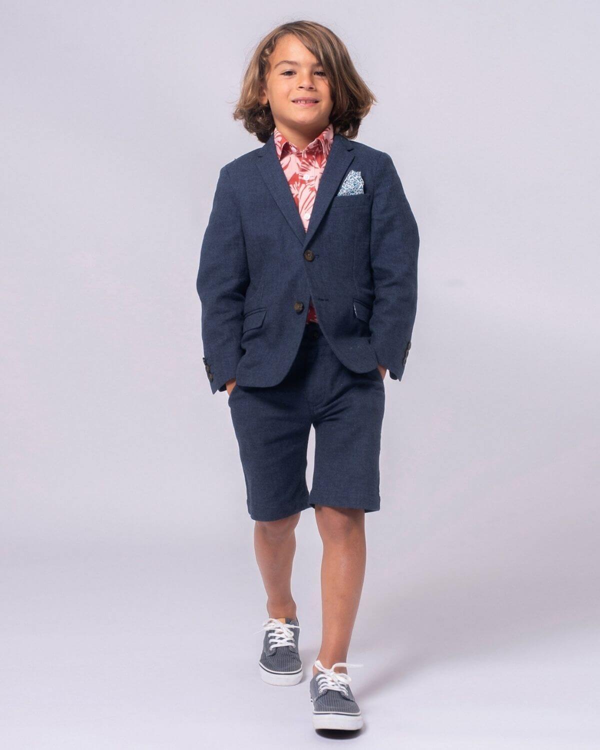 Stylish boy strutting in a navy blazer and vibrant shorts, ready for summer adventures in high-quality kids clothes.