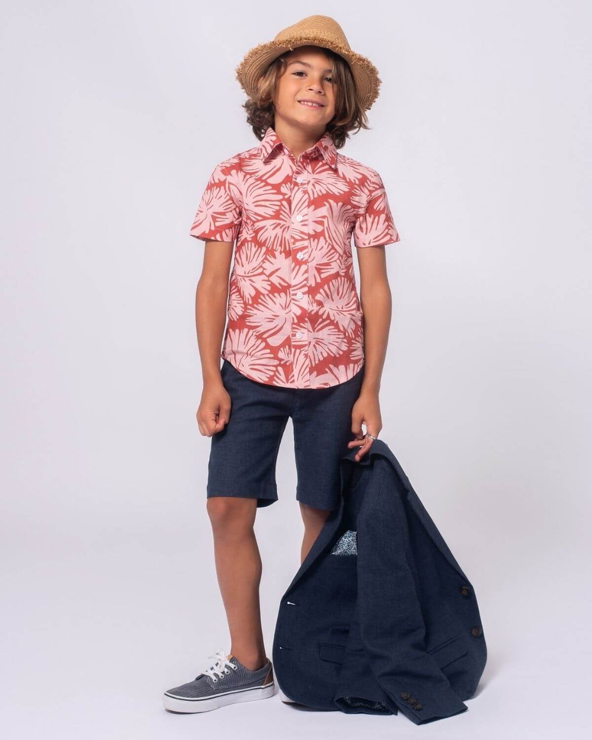 Stylish boy in vibrant floral shirt and shorts, ready for summer fun—perfect kids clothes for playdates or family adventures!