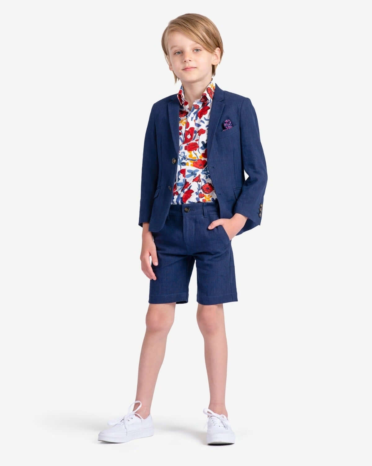 Stylish boy in dark navy trouser shorts with a vibrant floral shirt, ready for summer fun in high-quality, durable kids clothes.