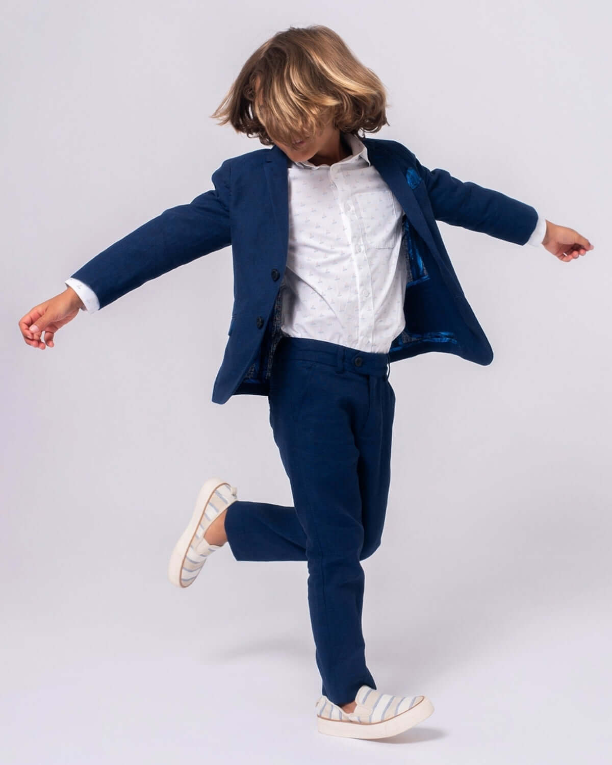 Stylish kid in estate blue linen stretchy suit pant, twirling with joy—ideal for weddings and family dinners!