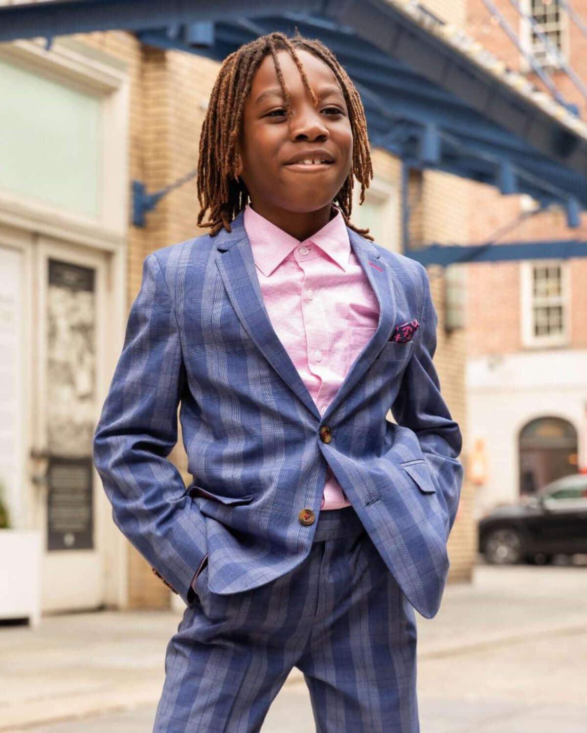 A stylish boy confidently posing in a chic indigo plaid suit, ready to steal the spotlight at any special event!