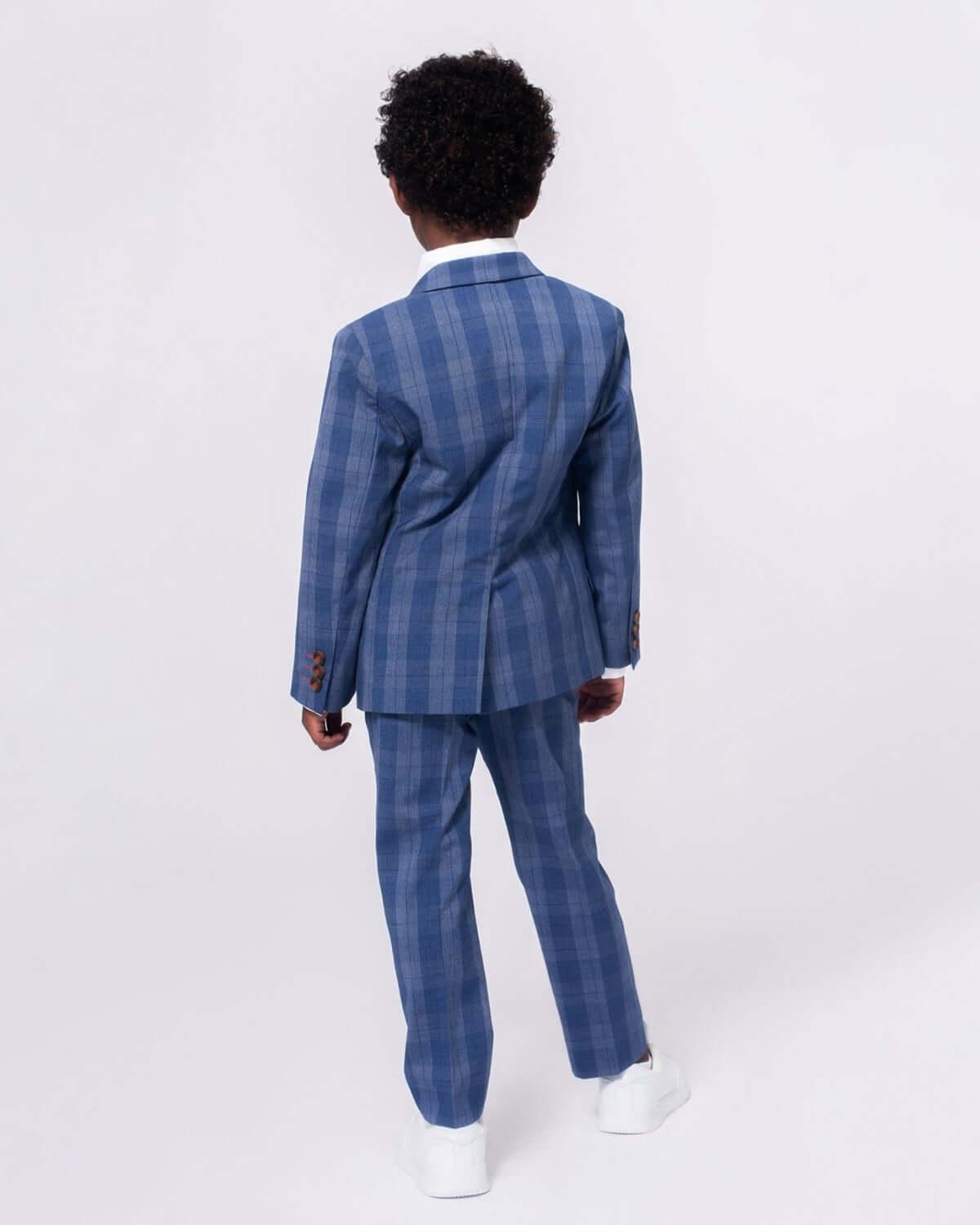 Stylish boy in indigo plaid suit pants and jacket, confidently ready for parties and special occasions.
