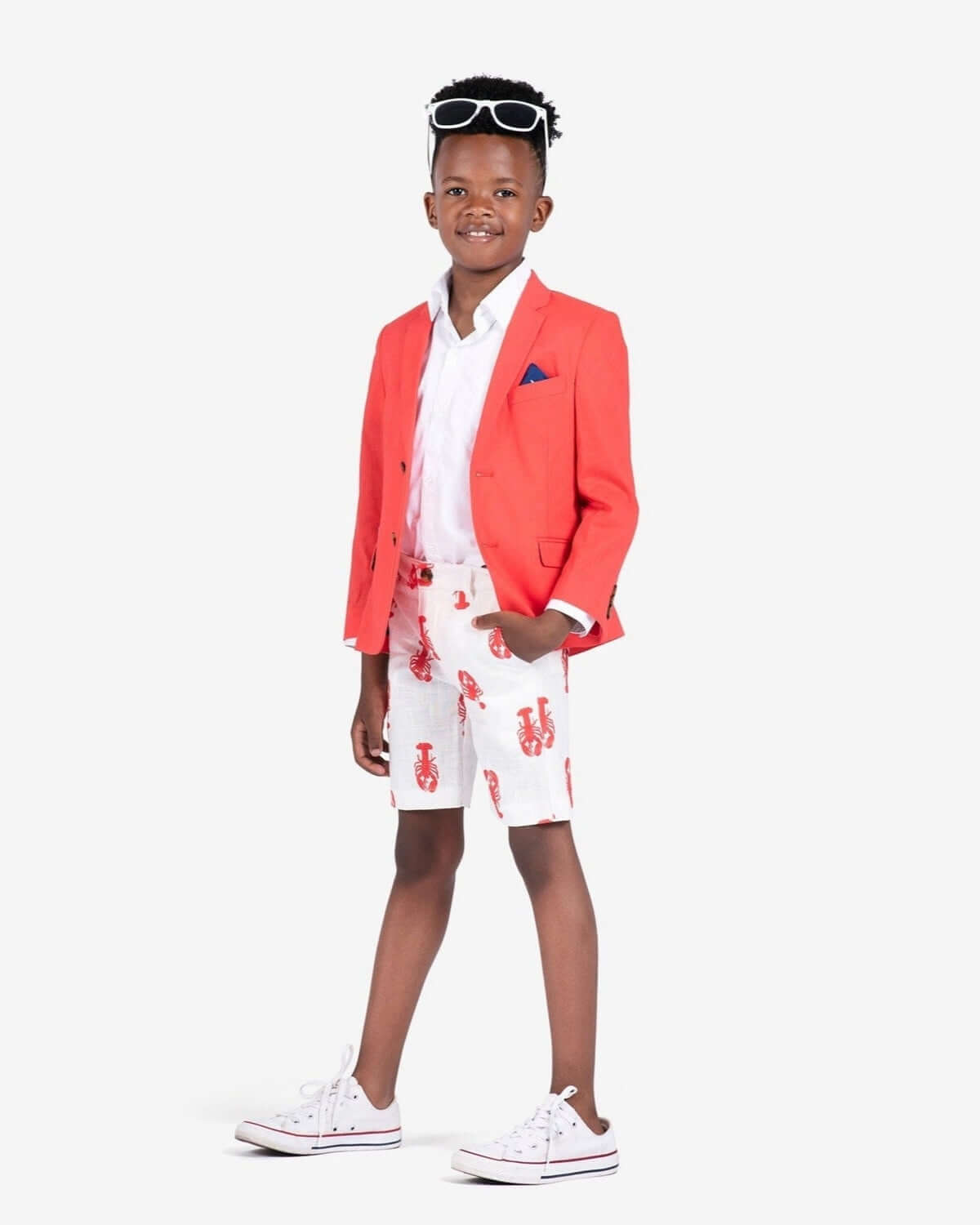 Stylish kid rocking lobster trouser shorts and a coral blazer—perfect for summer fun and back-to-school vibes!