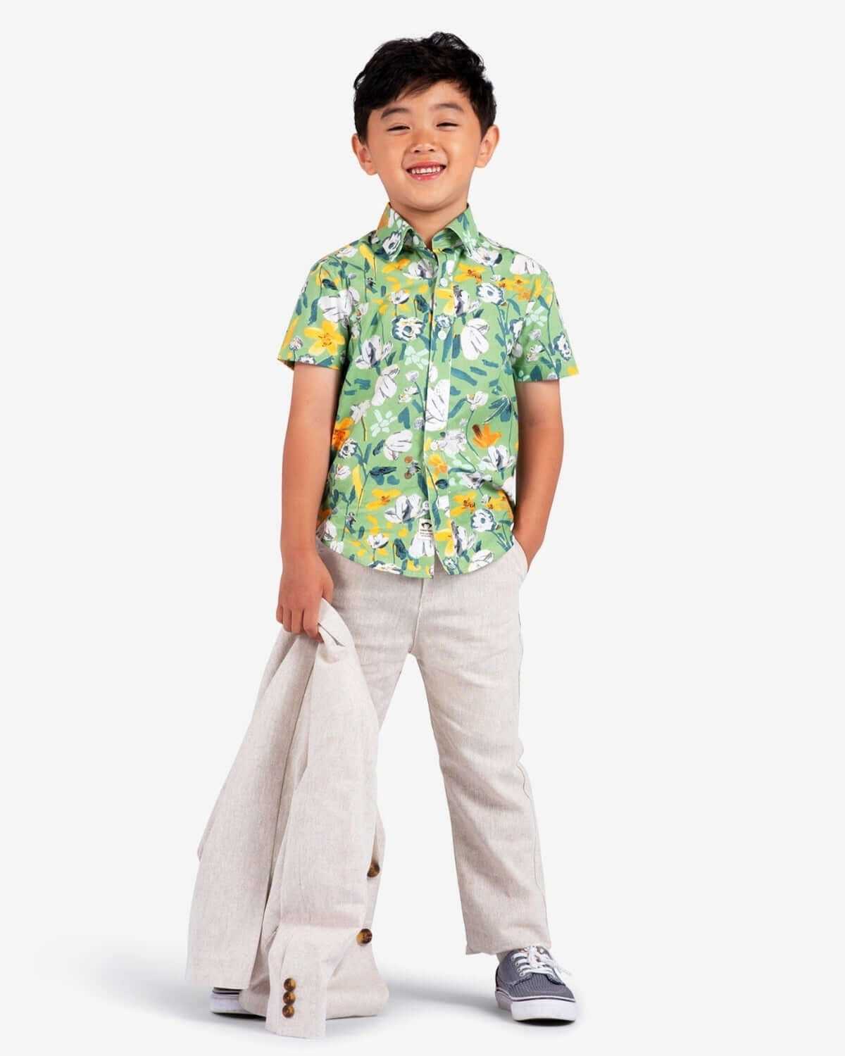 Stylish boy in a leafy shirt and linen beach pants, ready for fun outings in high-quality kids clothes.