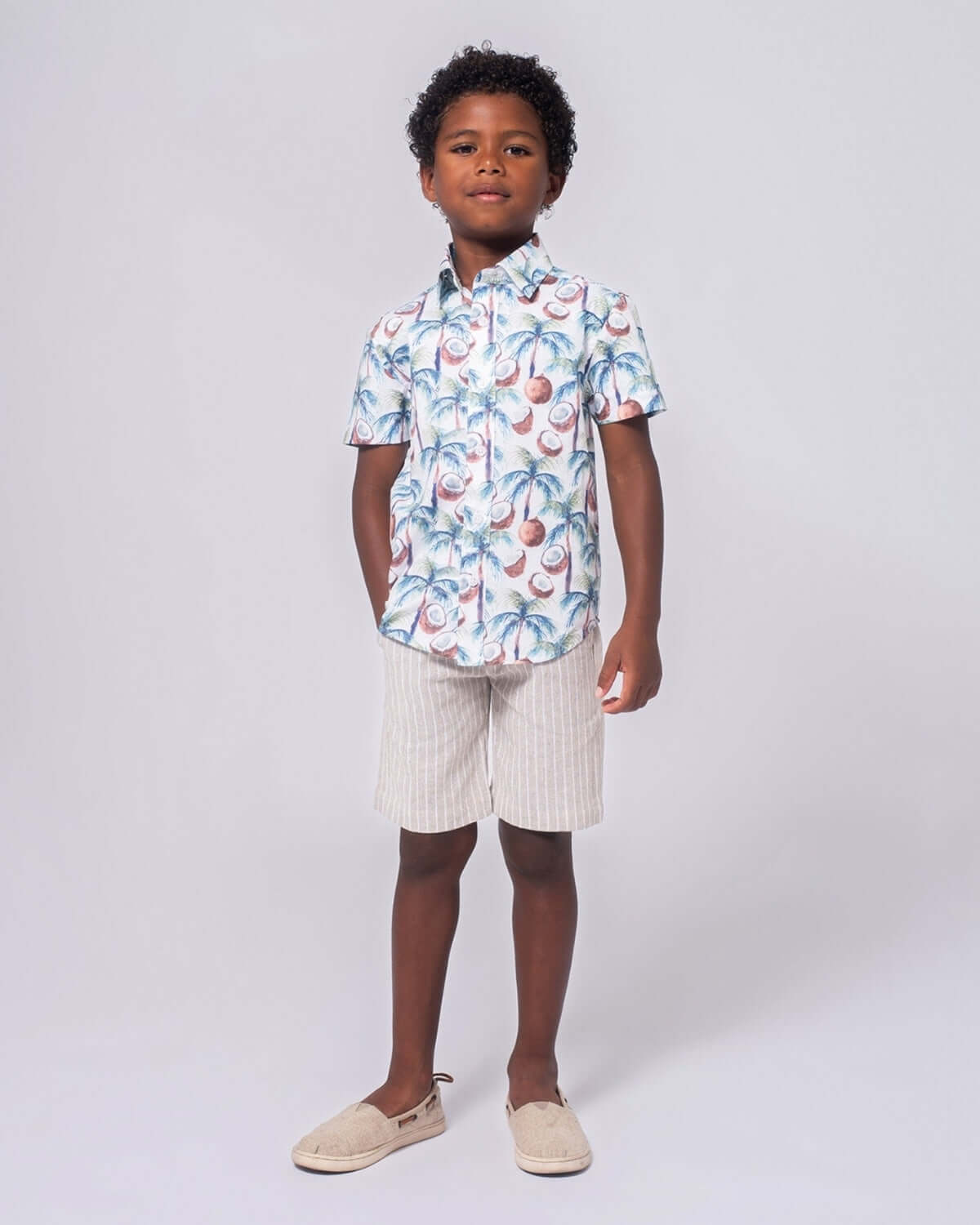 A child wearing a colorful shirt with Sand Stripe Linen Trouser Shorts, perfect for summer adventures.