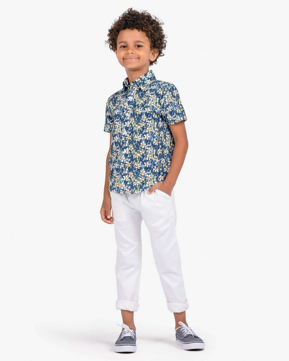 Stylish kid rocking a floral shirt paired with chic white resort pants—perfect for sunny days and playful adventures!