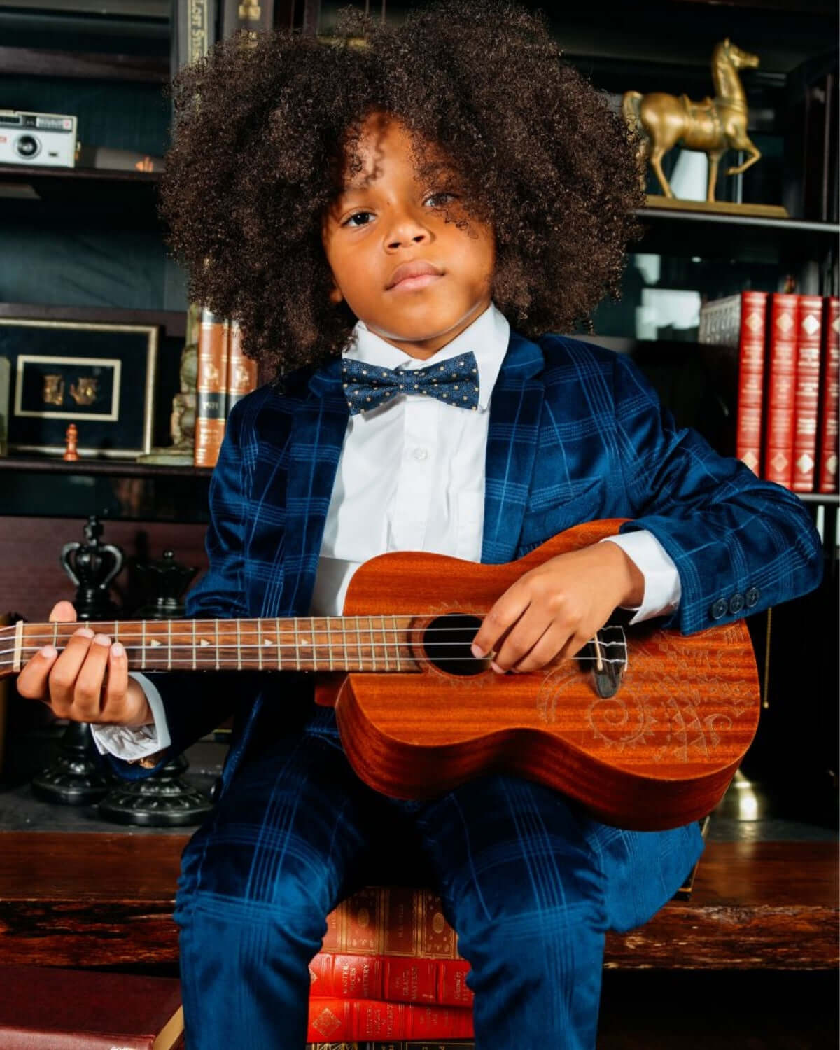 Stylish kid in a blue velvet suit blazer and bow tie, strumming a ukulele—perfect for holidays and special events!