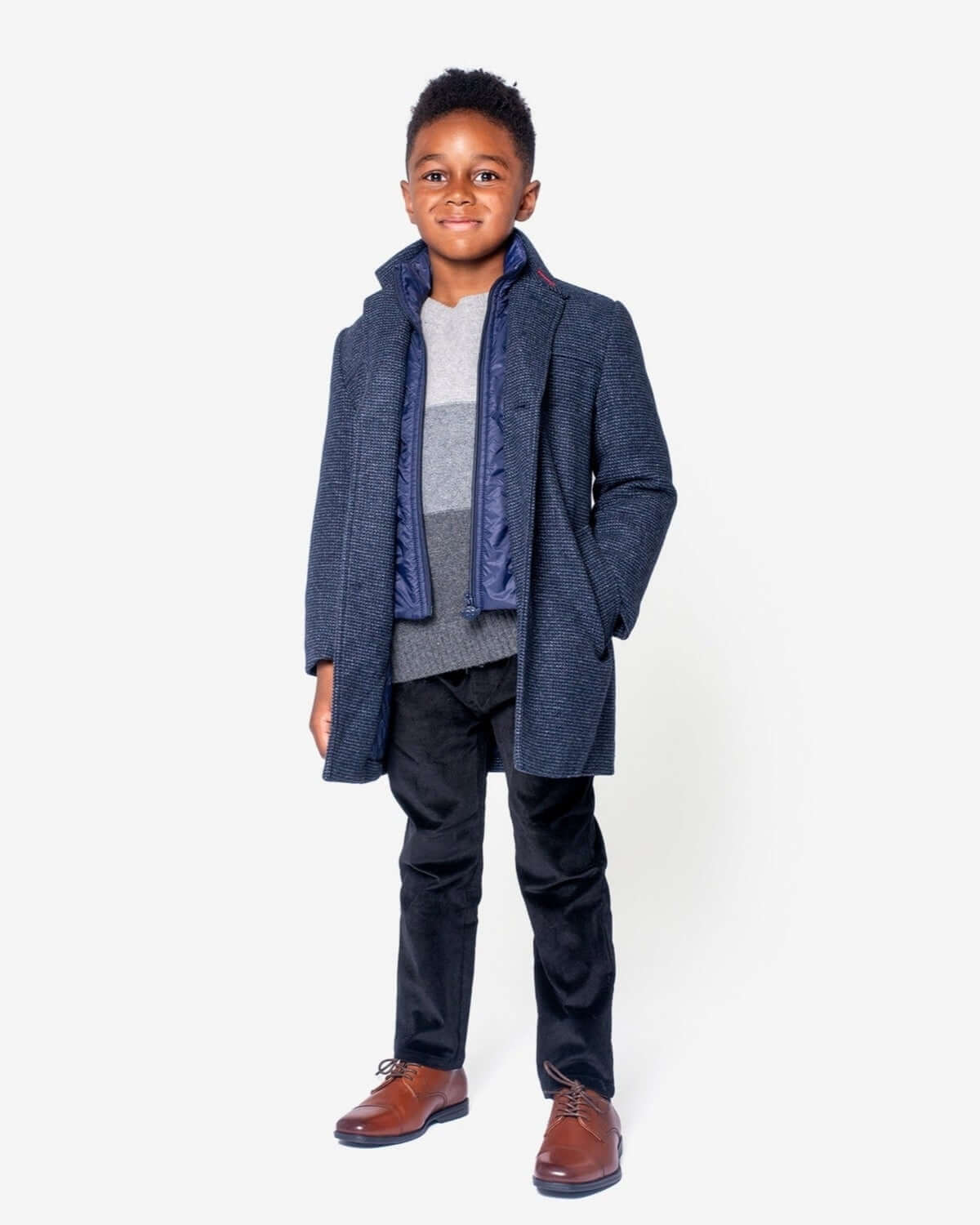 Stylish boy rocking the Checkered Ink City Overcoat, ready for chilly formal events in high-quality kids clothes.