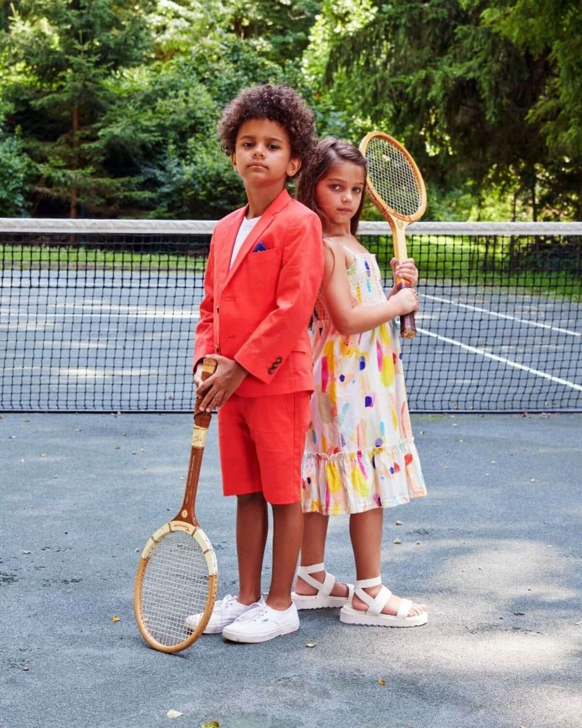 Stylish kids rocking coral sports jackets and playful dresses, ready for fun on the tennis court! High-quality, playful kids clothes.