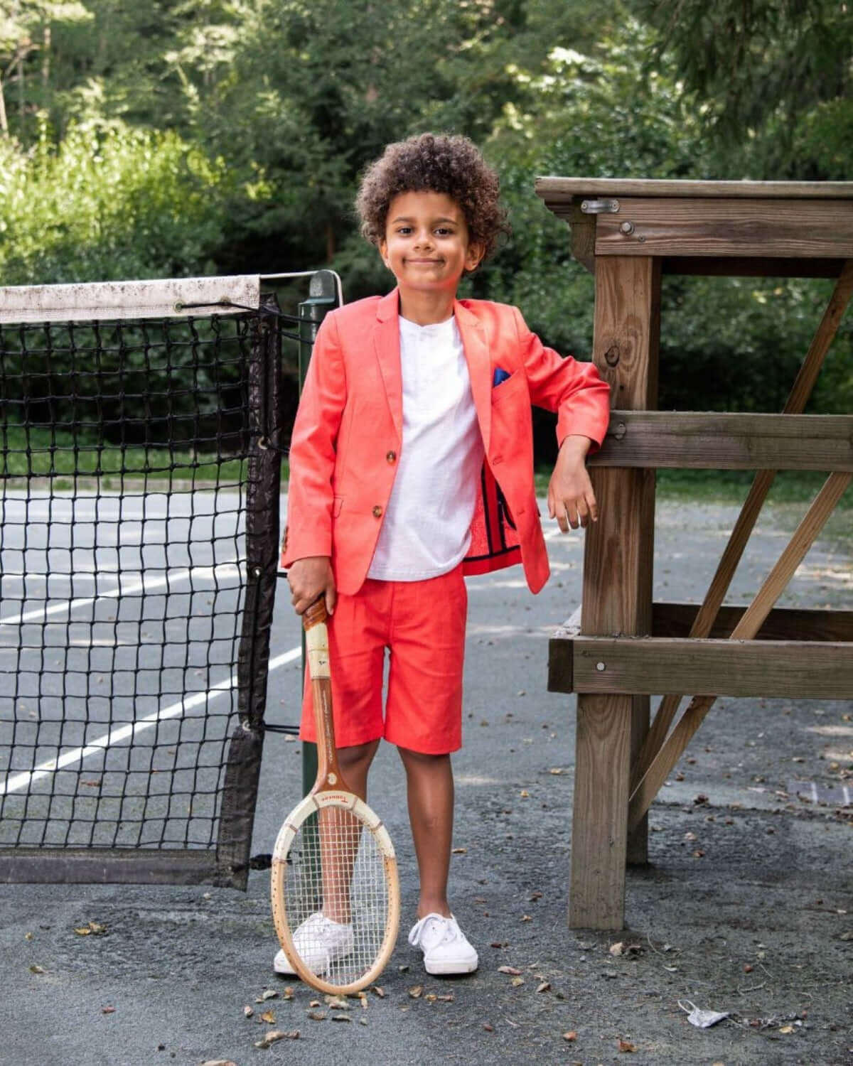 Stylish boy in coral sports jacket and shorts, ready for fun on the court—kids clothes that make a statement!