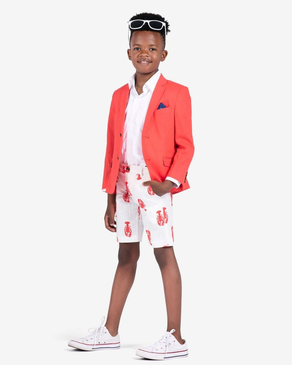 Stylish kid rocking a coral sports jacket with lobster shorts and cool sunglasses—perfect for back to school vibes!