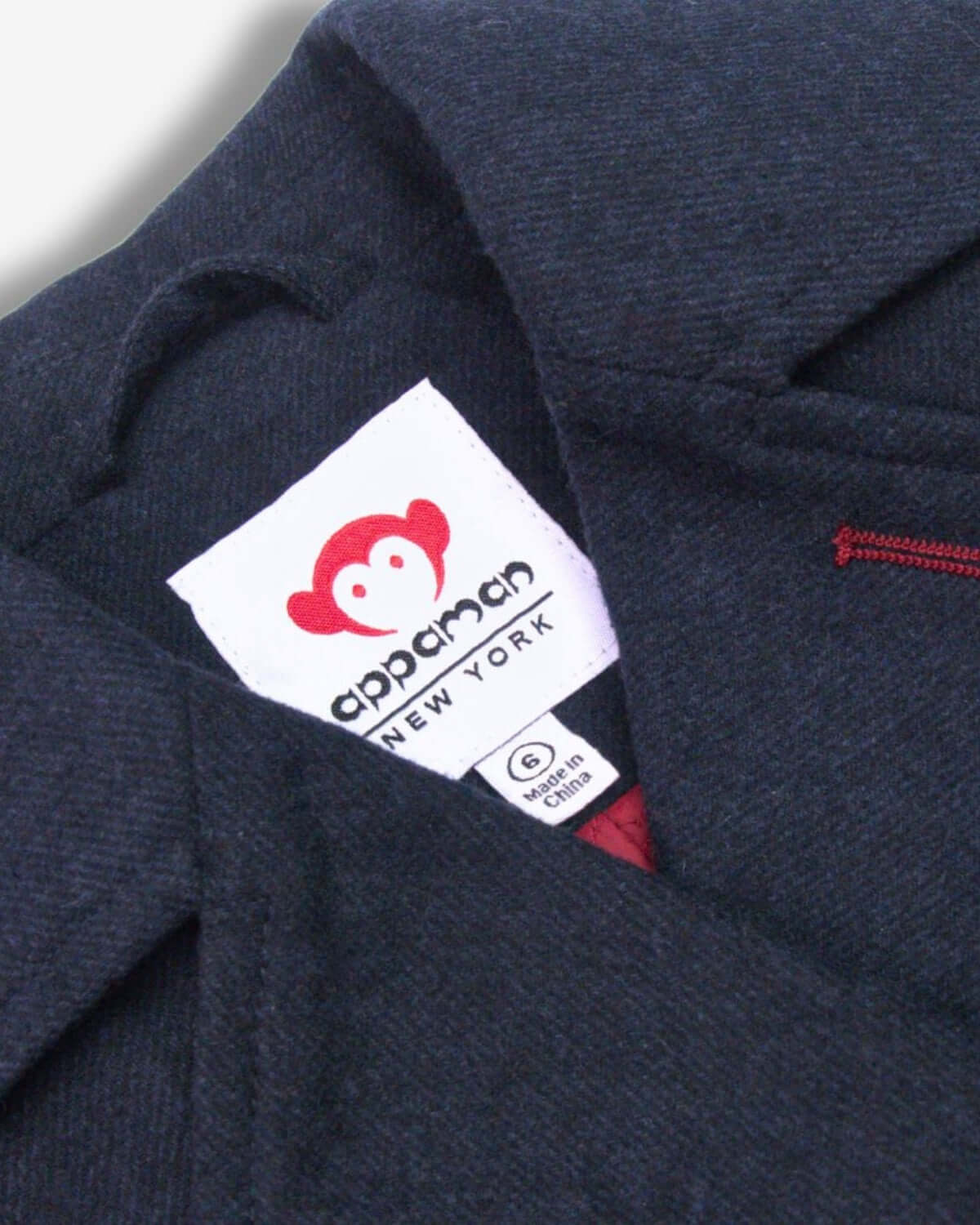 Cozy neckline of the Midnight Navy Pelham Peacoat showcasing Appaman's playful branding—stylish kids clothes for a cool season.