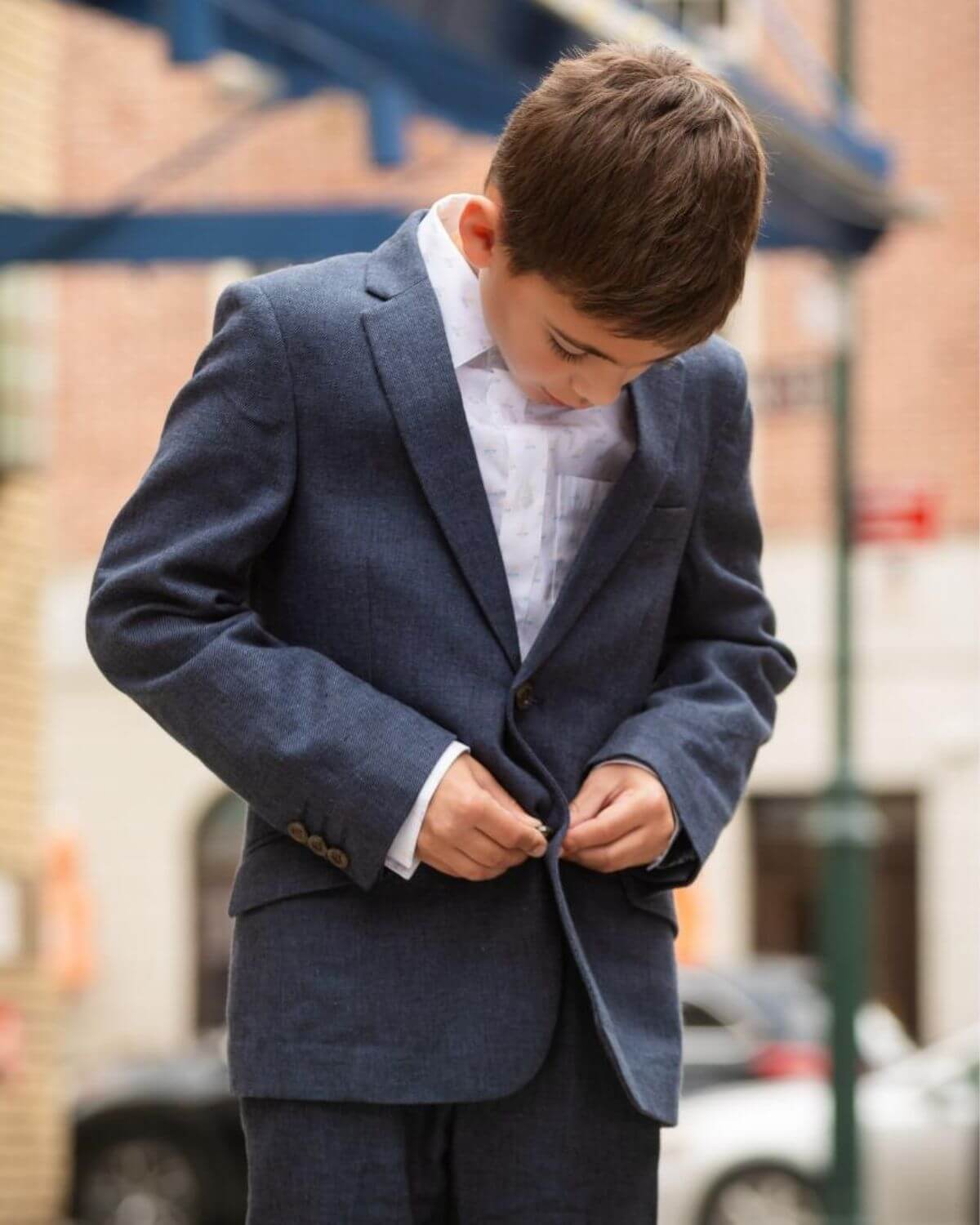 Blue Nights Linen Sports Jacket worn by a boy adjusting his jacket outdoors, showcasing style and comfort.