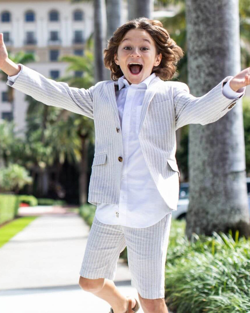 A happy boy in a stylish sand striped shorts suit, ready for fun adventures in high-quality kids clothes.