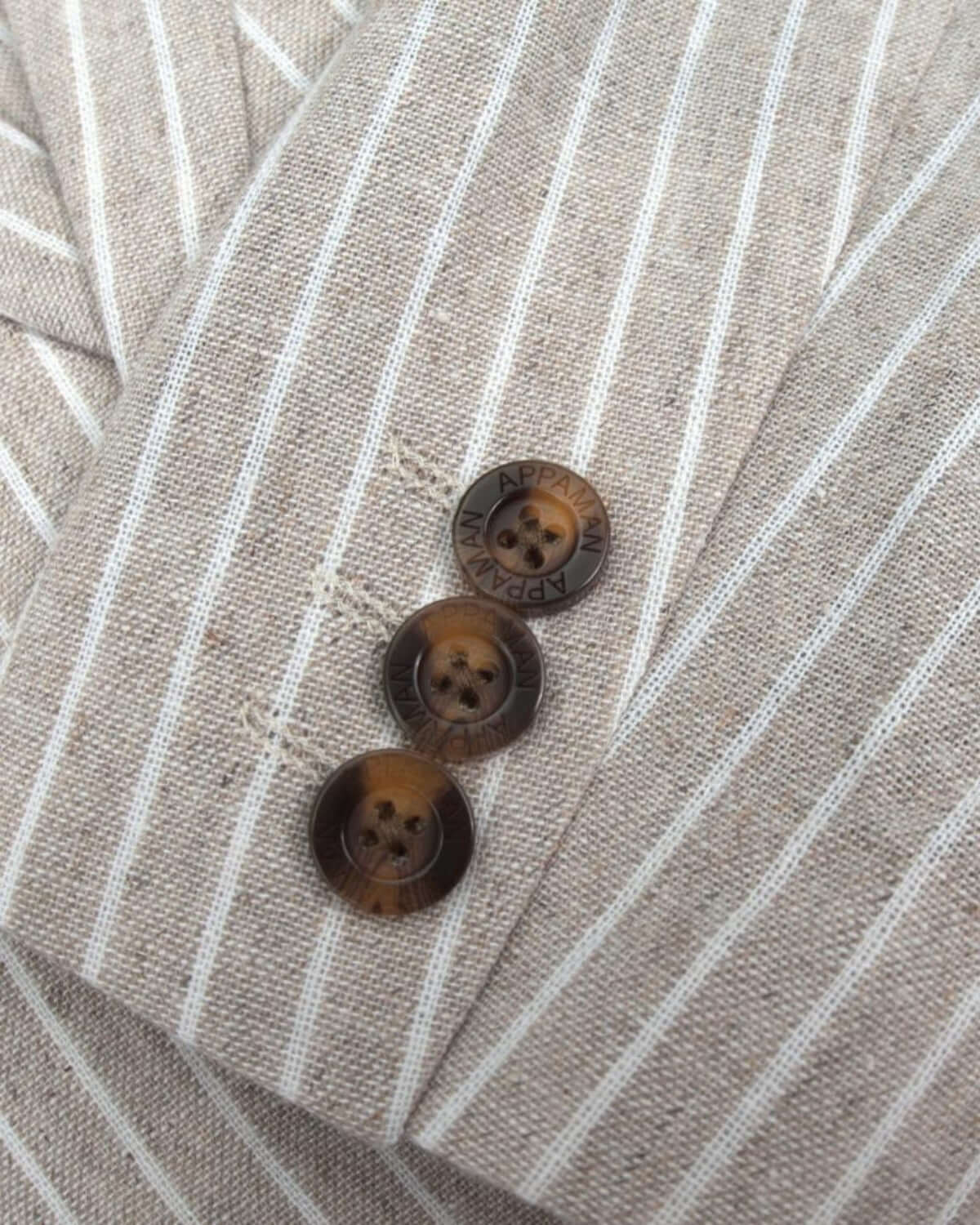 Close-up of stylish sand stripe linen jacket buttons—high-quality kids clothes, a fabulous back-to-school choice!