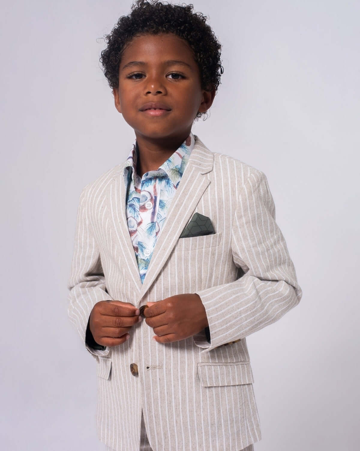 Charming boy in a sand stripe linen sports jacket, showcasing stylish kids clothes for back to school flair.