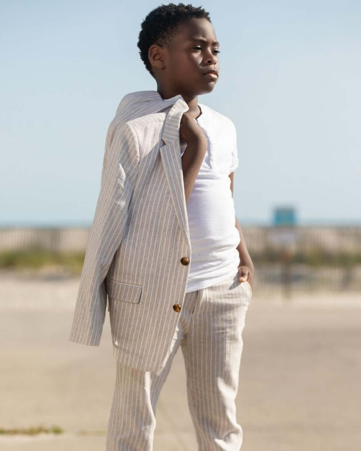Child wearing a Sand Stripe Linen Sports Jacket, showcasing a stylish and chic outfit by the beach.
