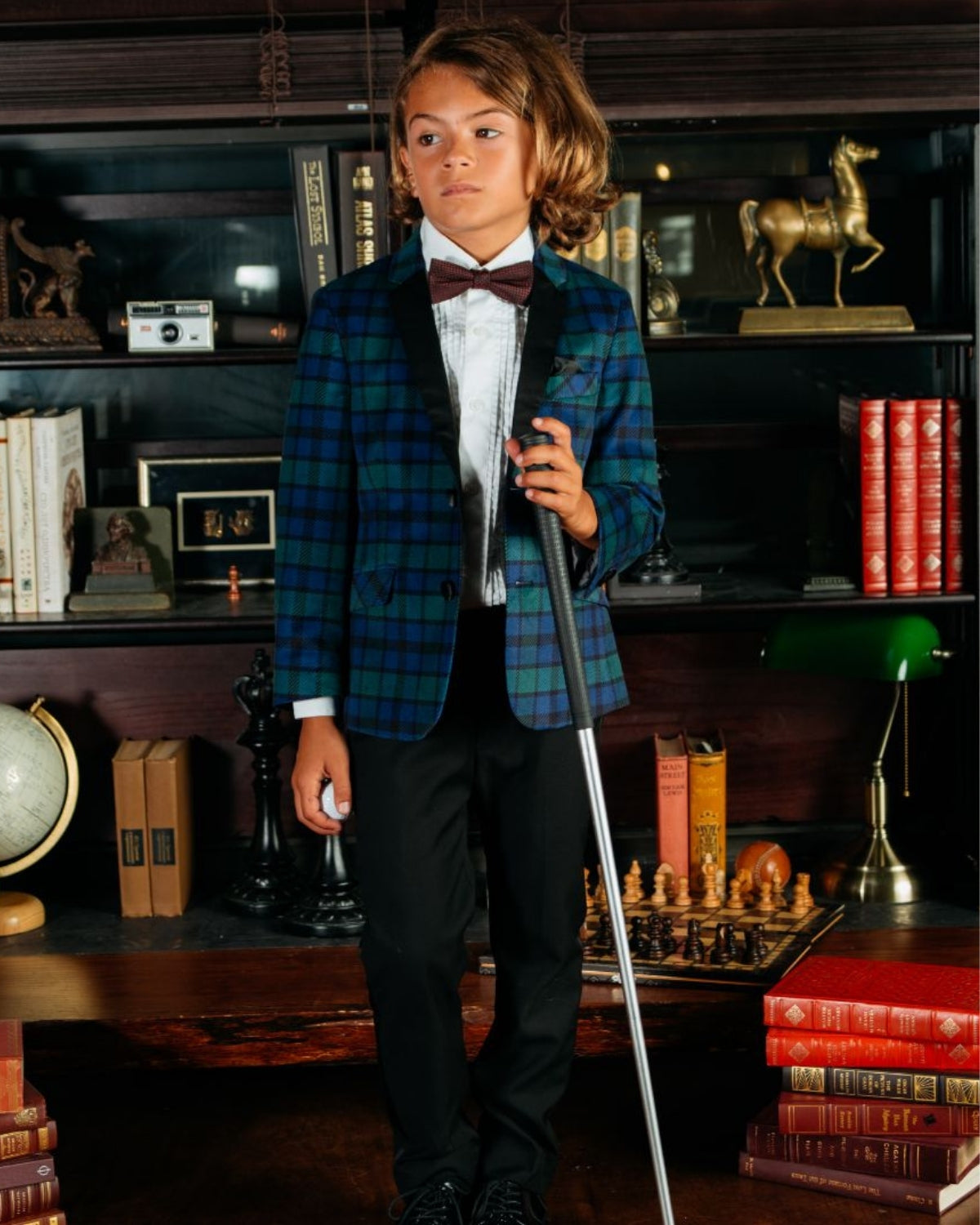 Stylish kid in a plaid blazer and tuxedo pants, ready for a classy event—perfect for trendy mini fashionistas!