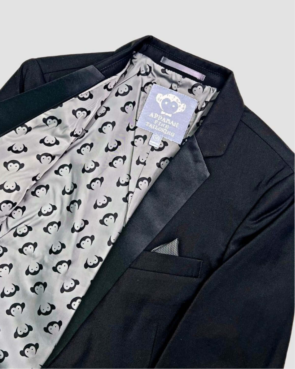 Sleek black tuxedo suit jacket with playful monkey lining—ideal for kids' formal style at special events!