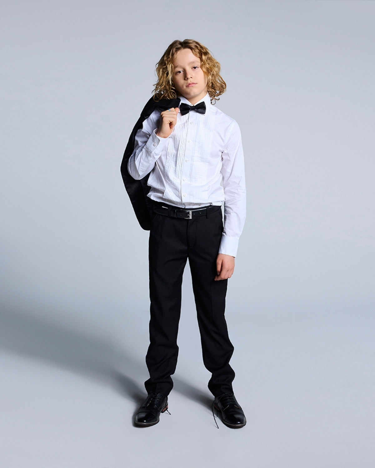 Stylish little gentleman in a black tuxedo jacket, looking sharp for Black Tie events—trendy kids clothes at their best!