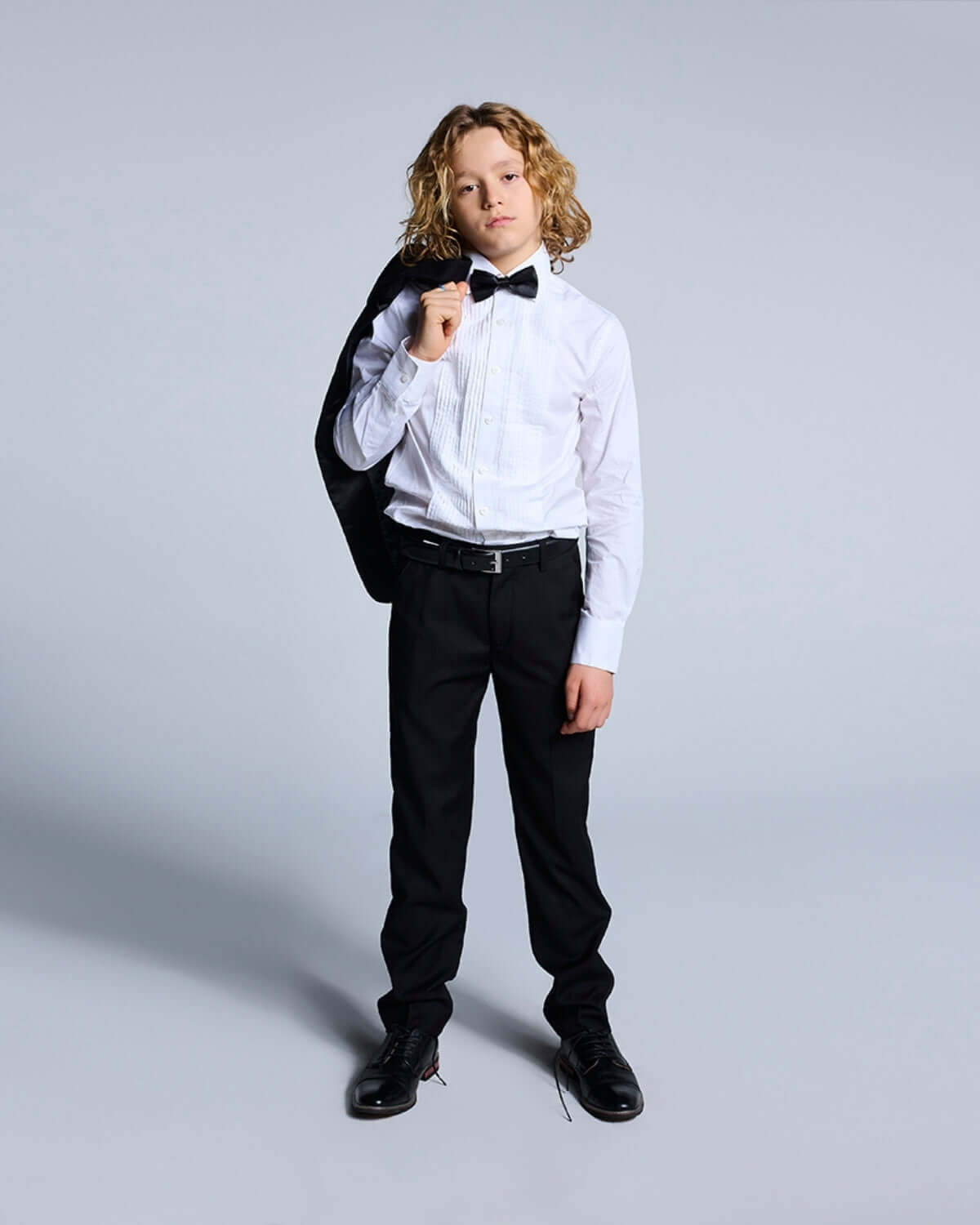 Boy dressed in a Black Tuxedo Suit Jacket with bow tie, ready for a formal event.