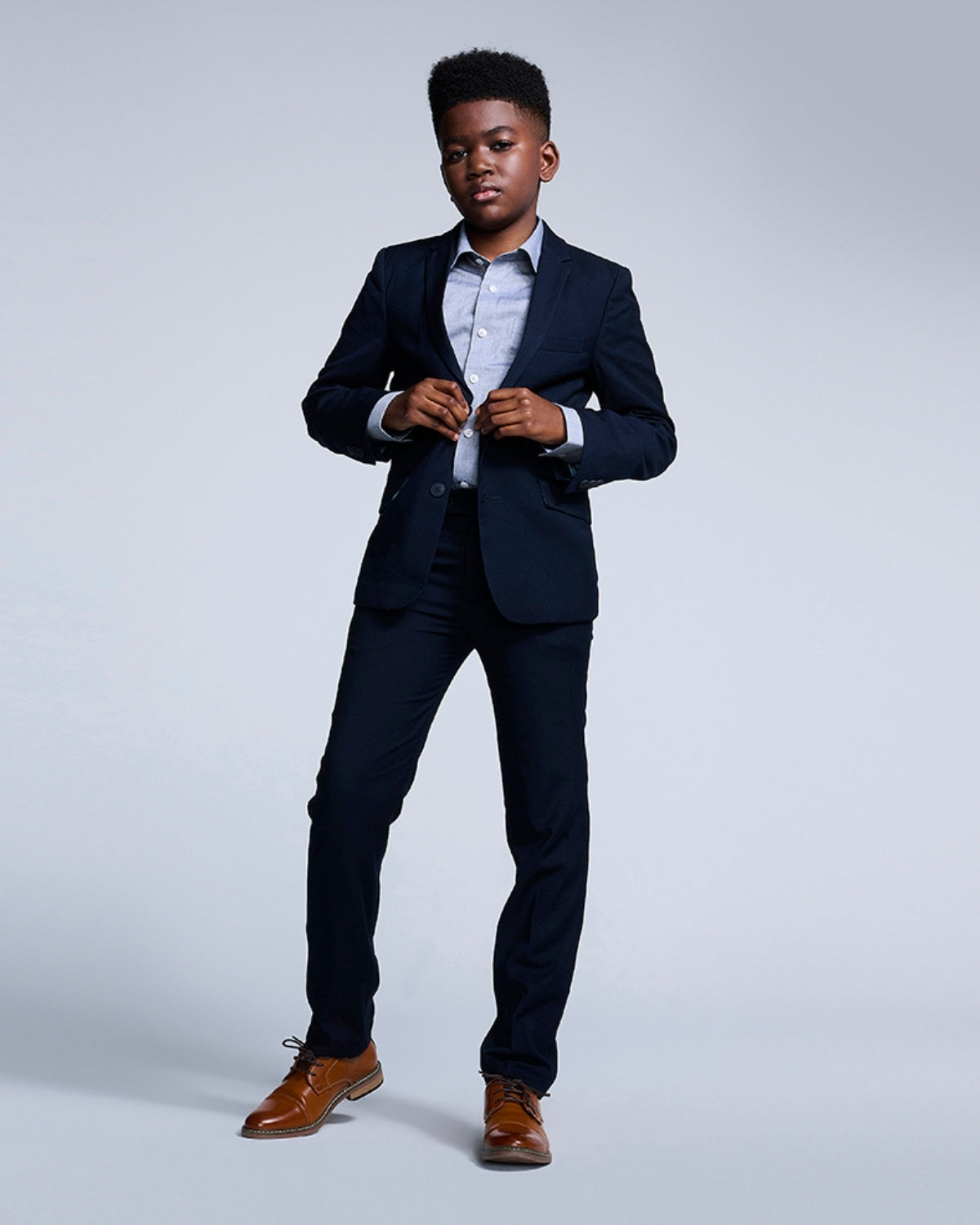 Dapper boy rocking a navy blue suit, showing off style and confidence for special occasions and back to school events.
