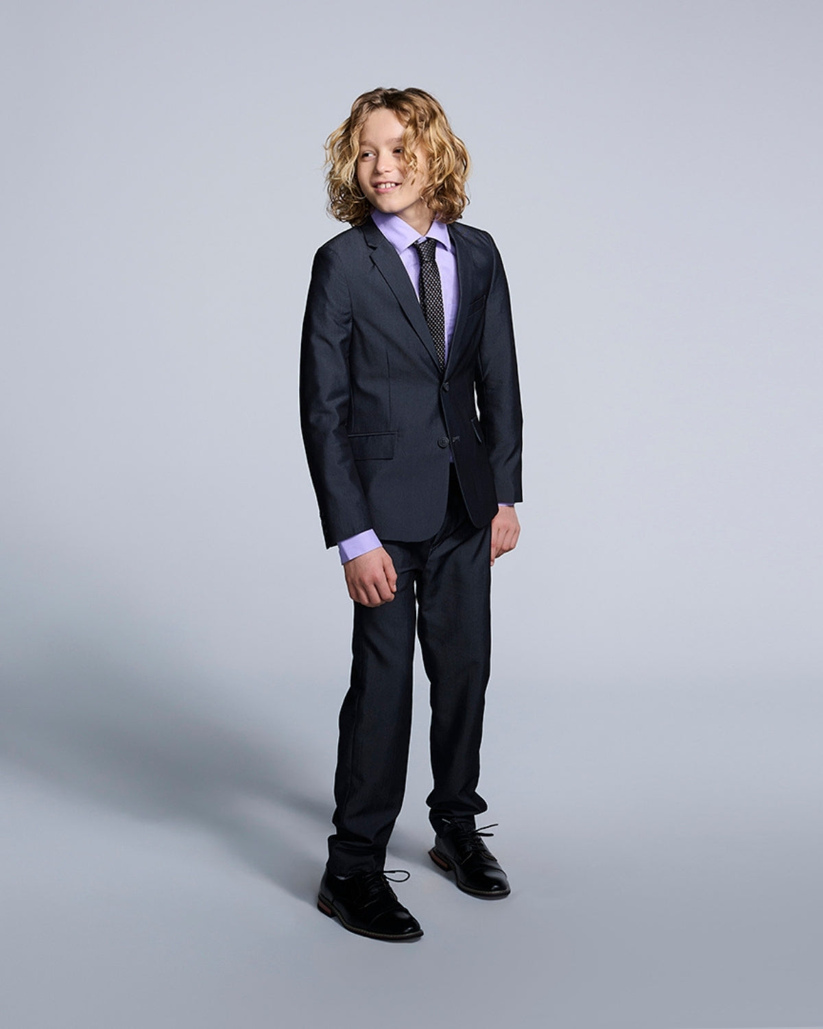 Stylish boy in a tailored suit and lavender shirt, ready for back to school or a special event, showcasing high-quality kids clothes.