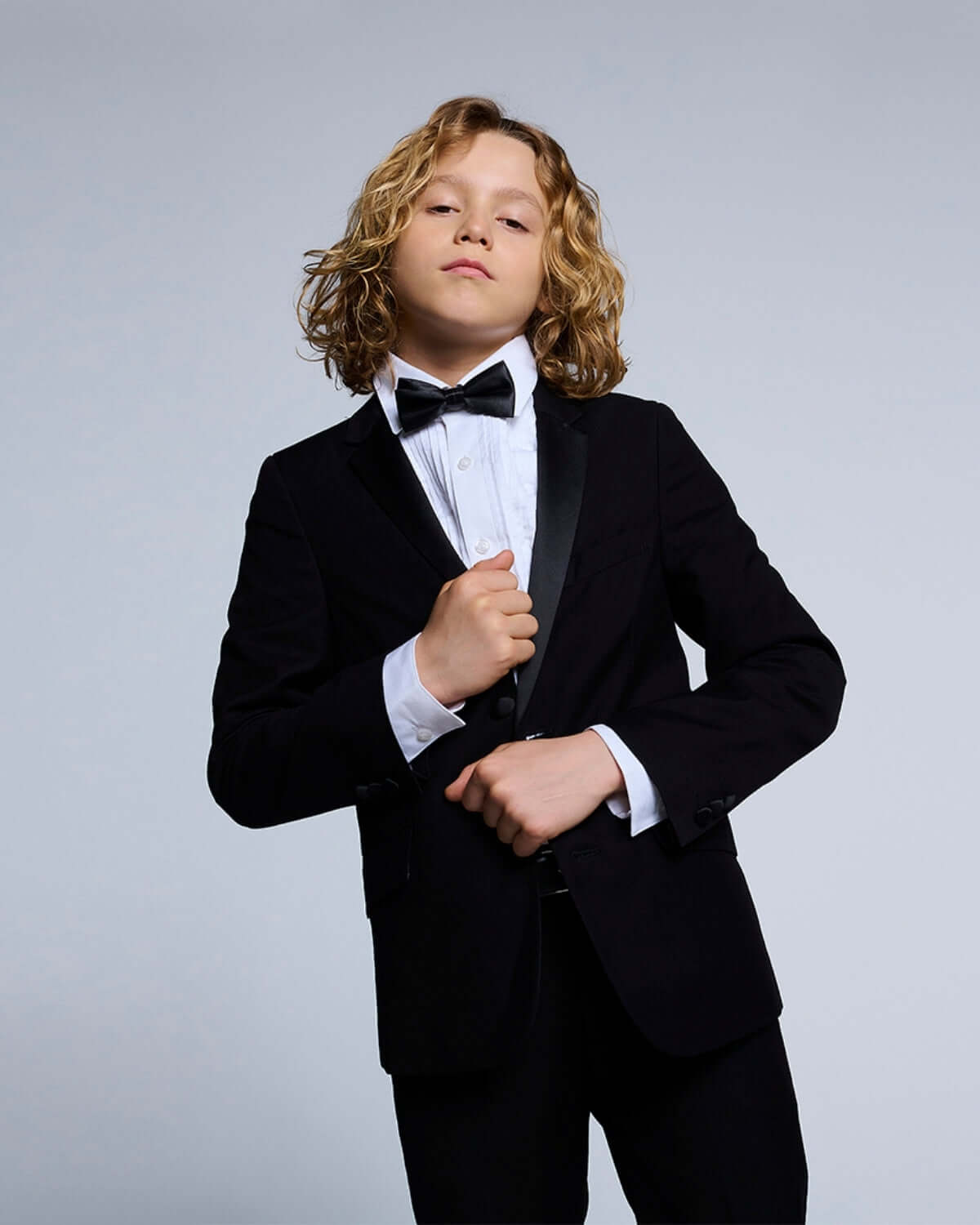 Young boy wearing a tuxedo with a bow tie and White Tuxedo Shirt, ideal for formal events.