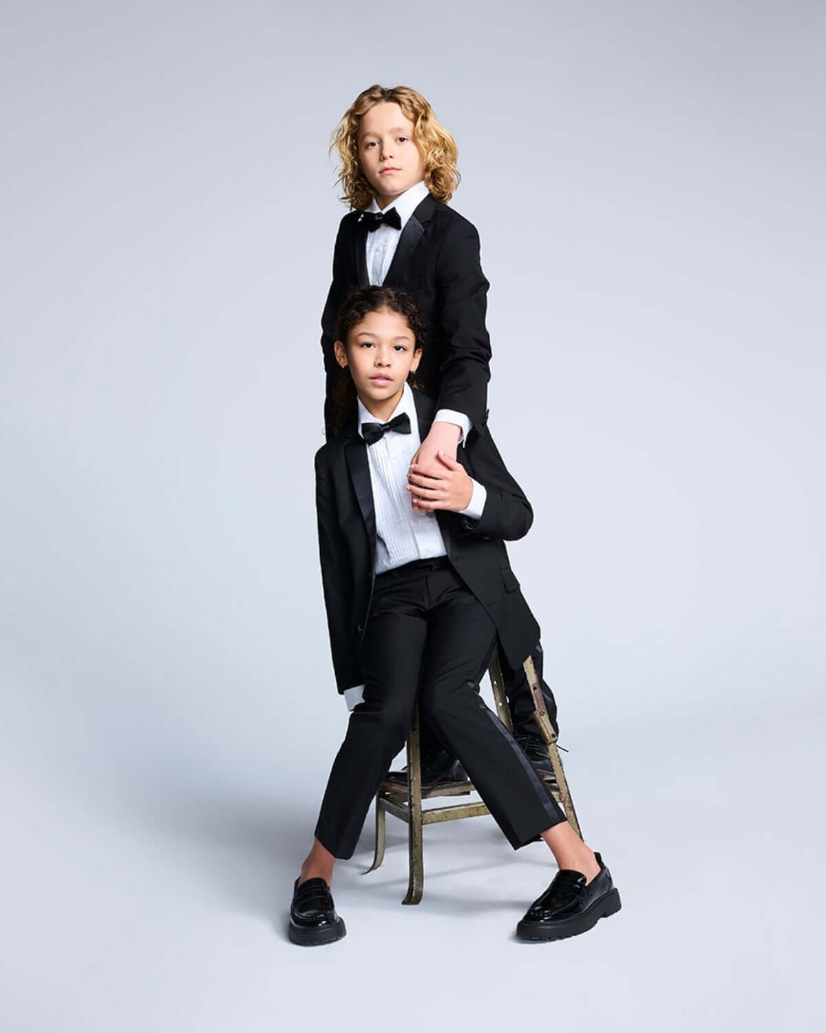 Two boys dressed in formal wear featuring a White Tuxedo Shirt, perfect for sophisticated occasions.