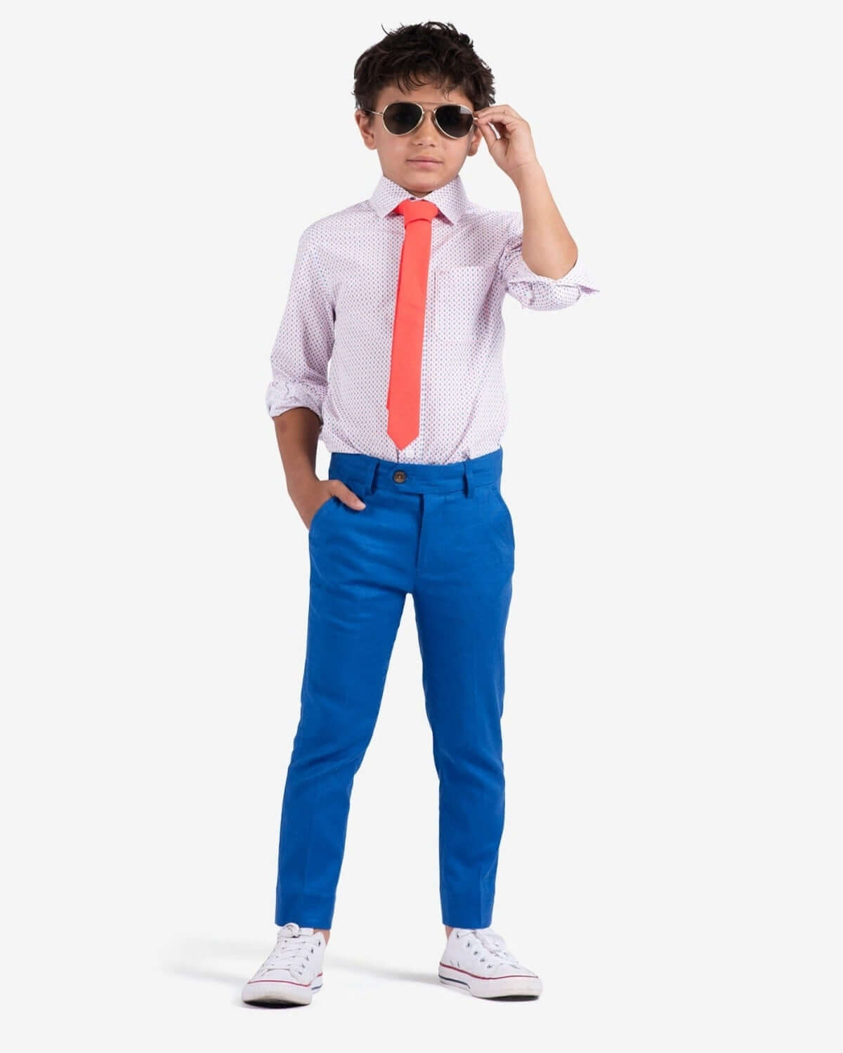 Stylish kid in a checkered shirt and bold blue pants, rocking shades and a red tie—perfect for confident young trendsetters!